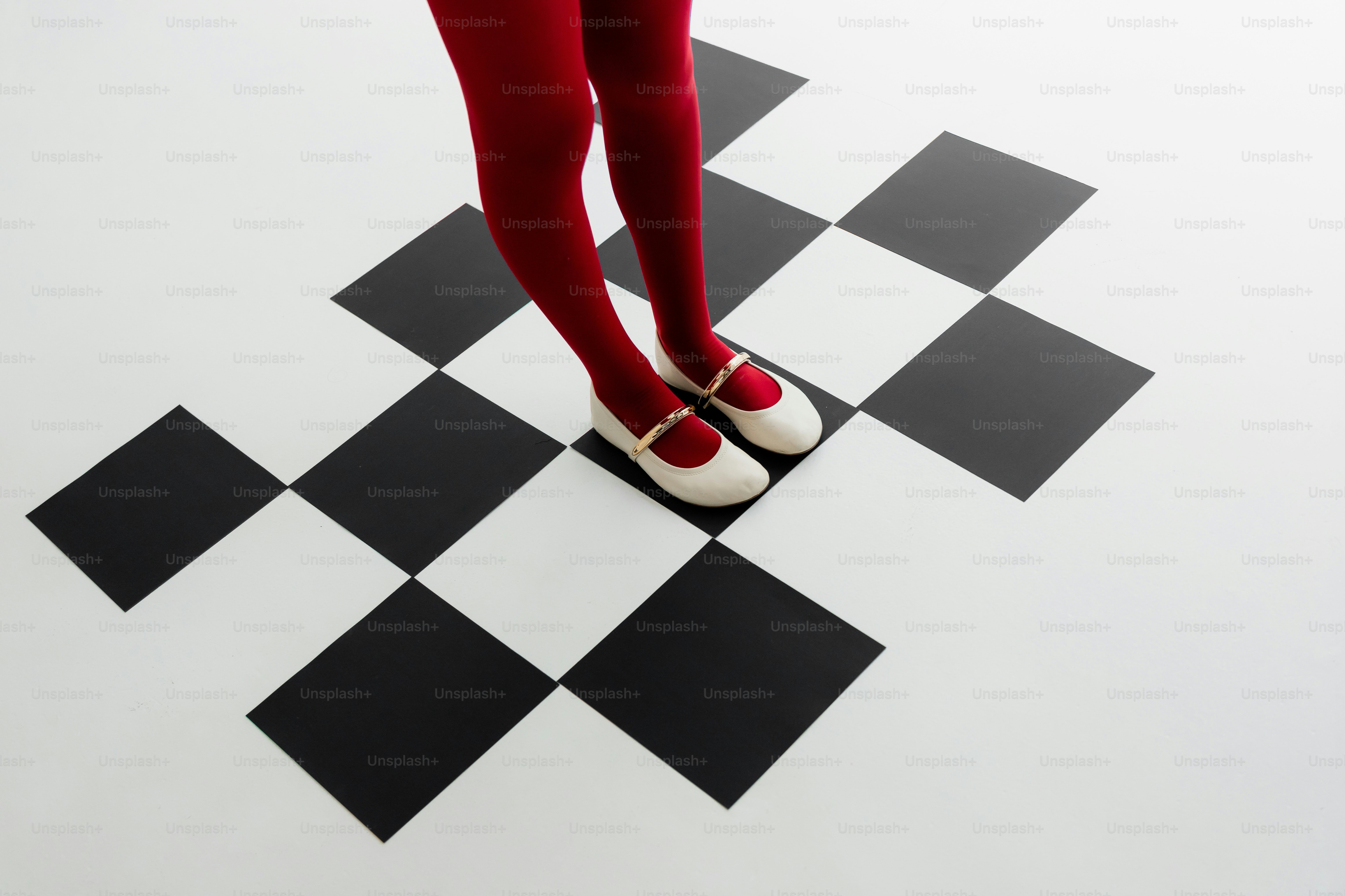 Beine in roten Strumpfhosen stehen auf karierten Boden