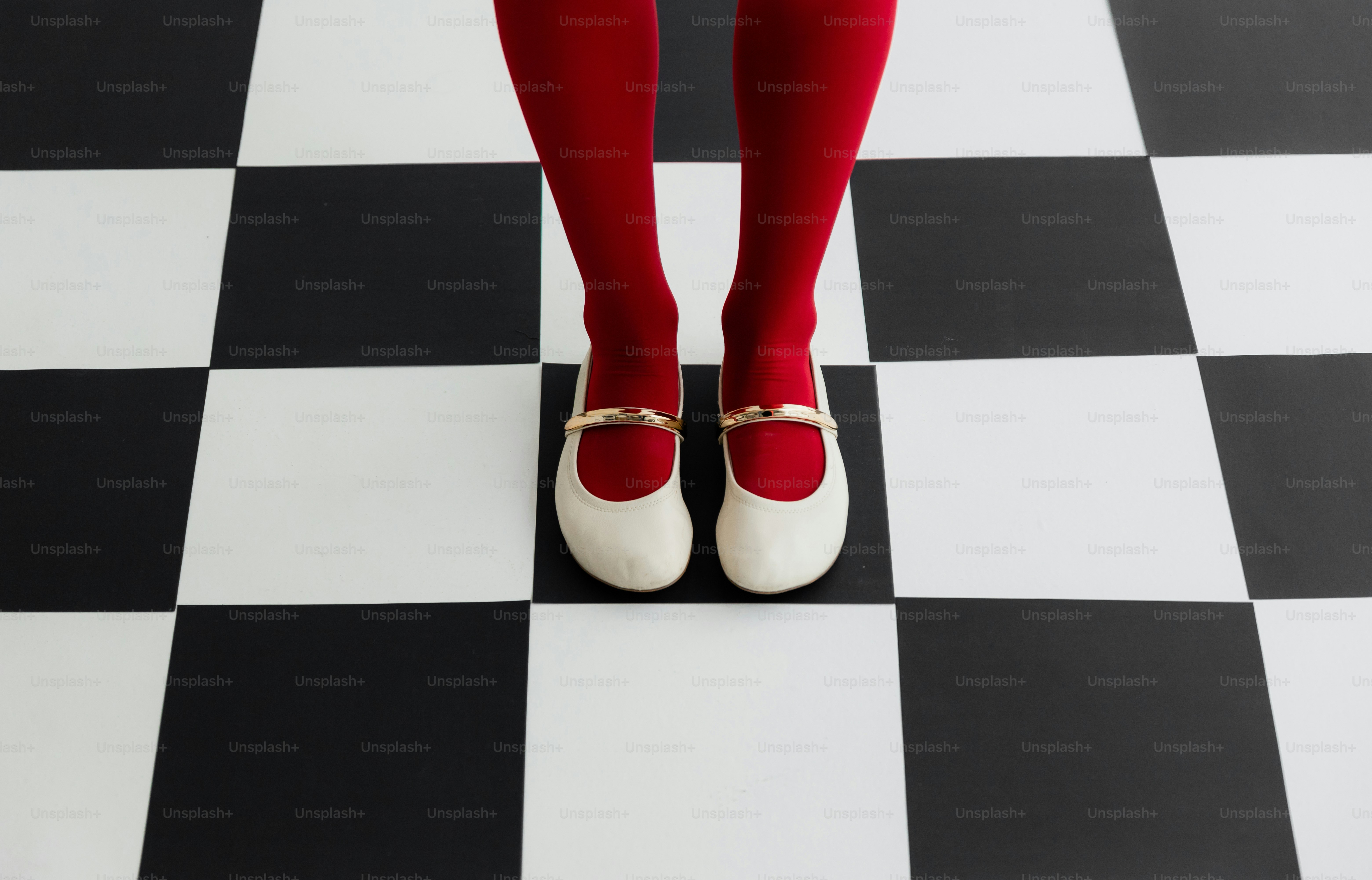 Rote Strumpfhosen und weiße Schuhe auf karierten Boden