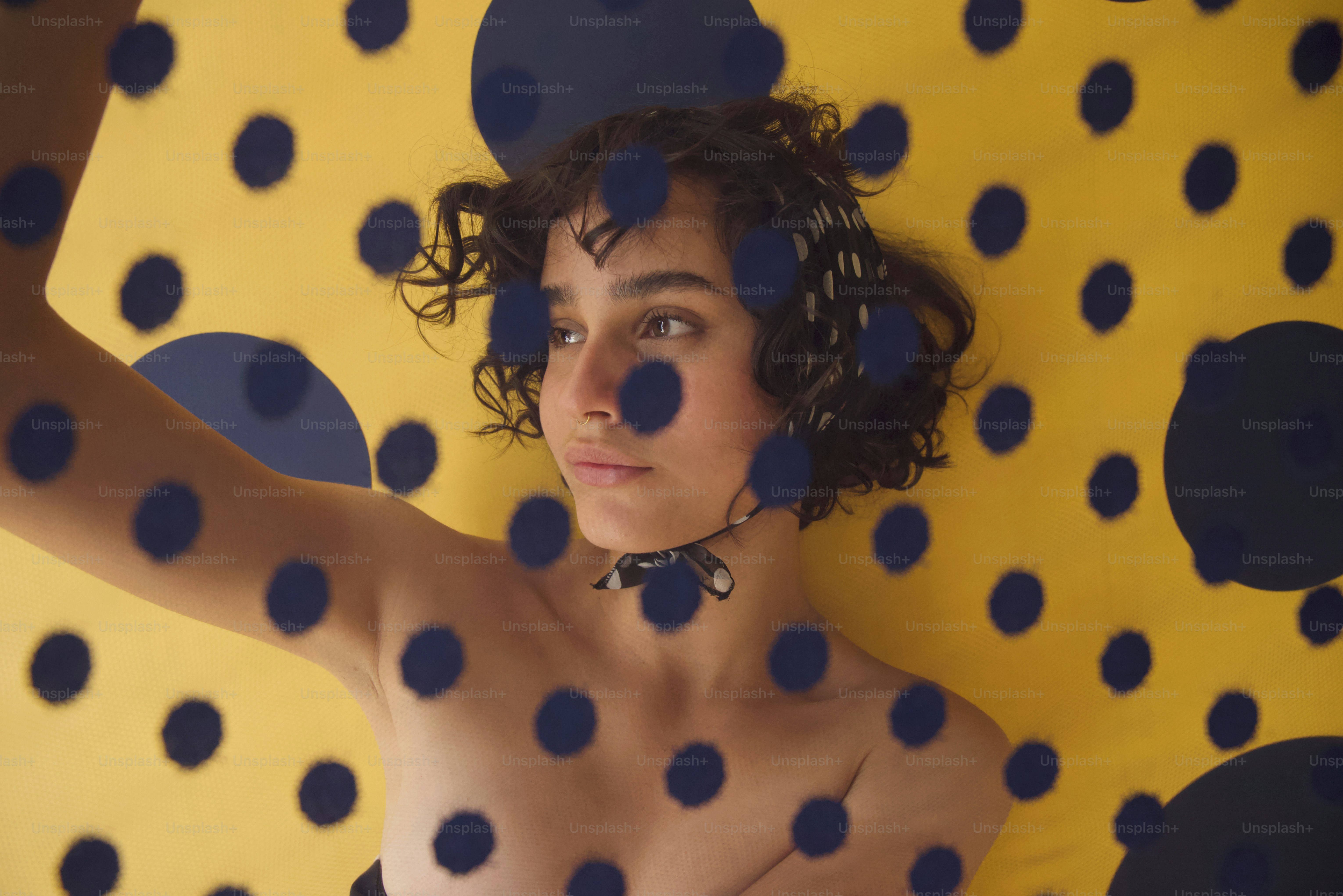Giovane con capelli scuri e ricci su pois gialli
