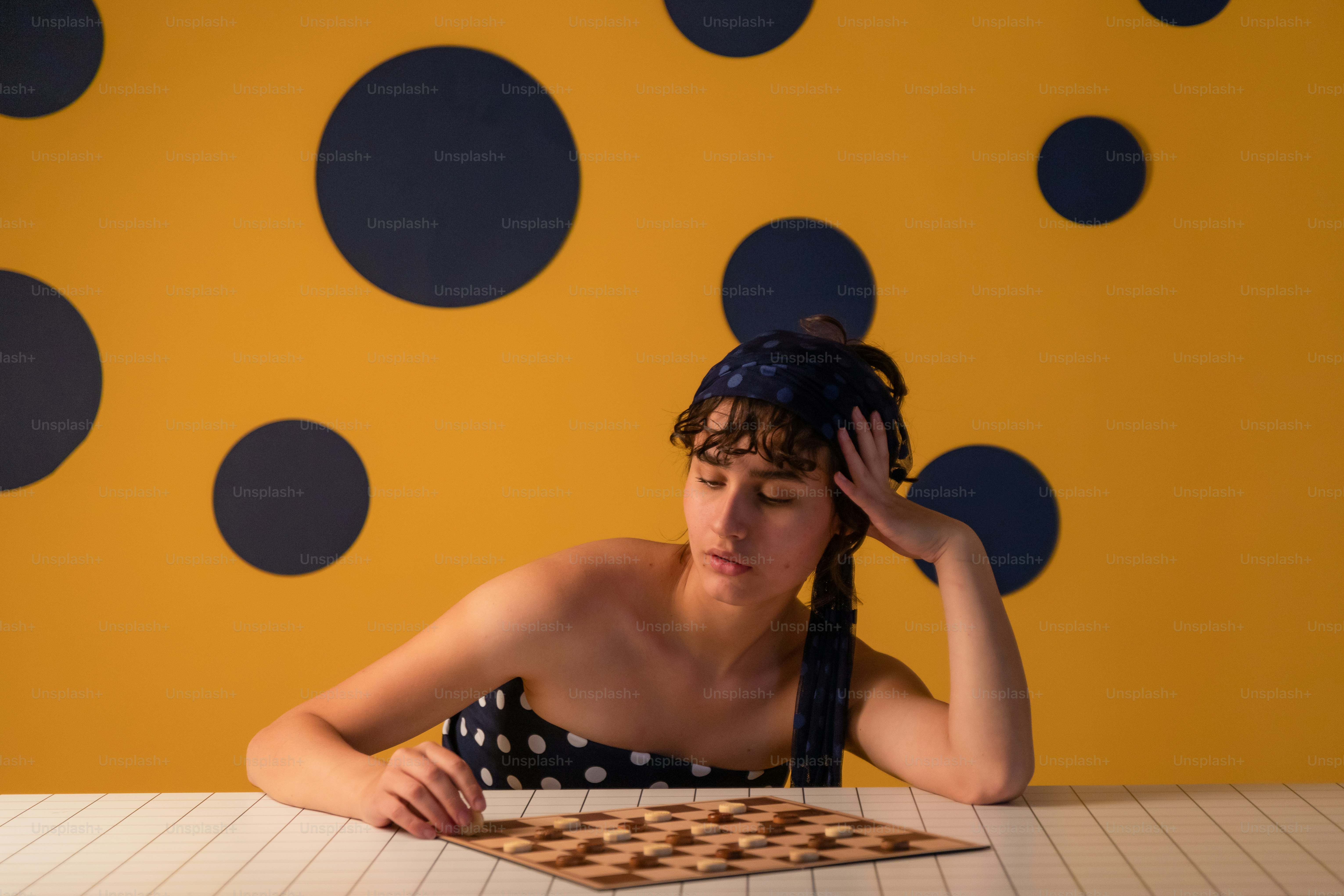 Woman sitting at table with checkerboard