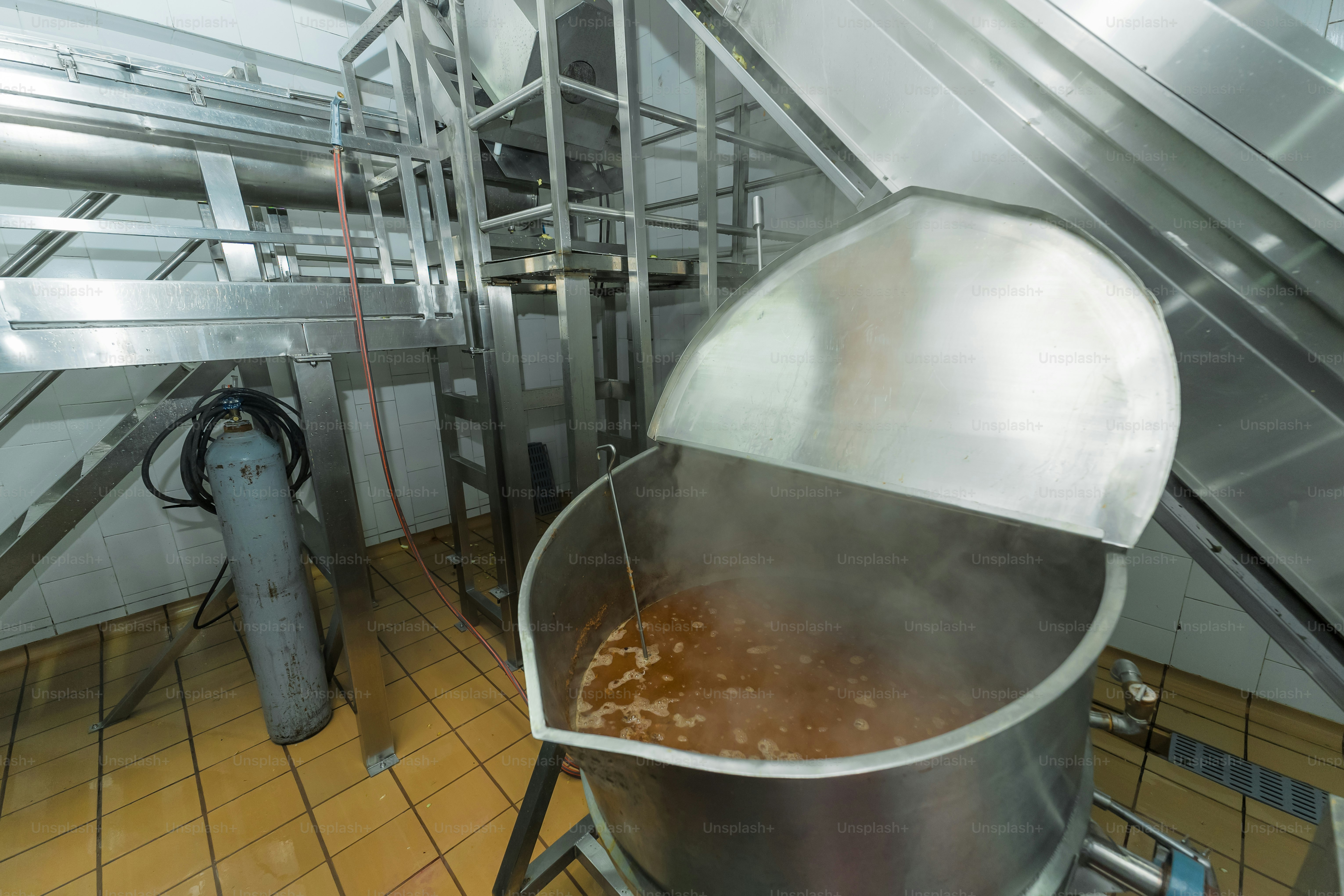 Industrial kitchen with large metal pot steaming