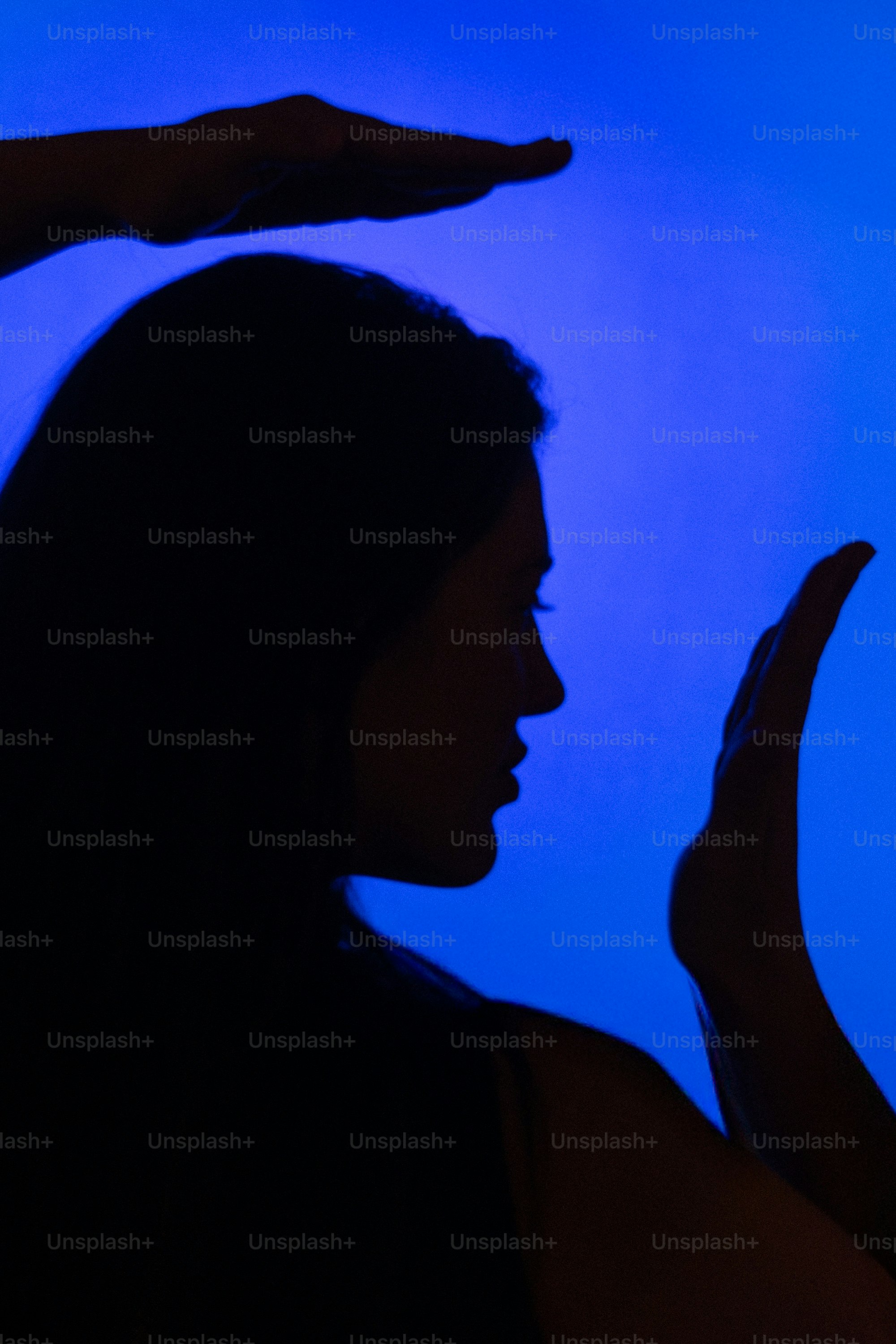 Silhouette of a woman with hands framing her face.