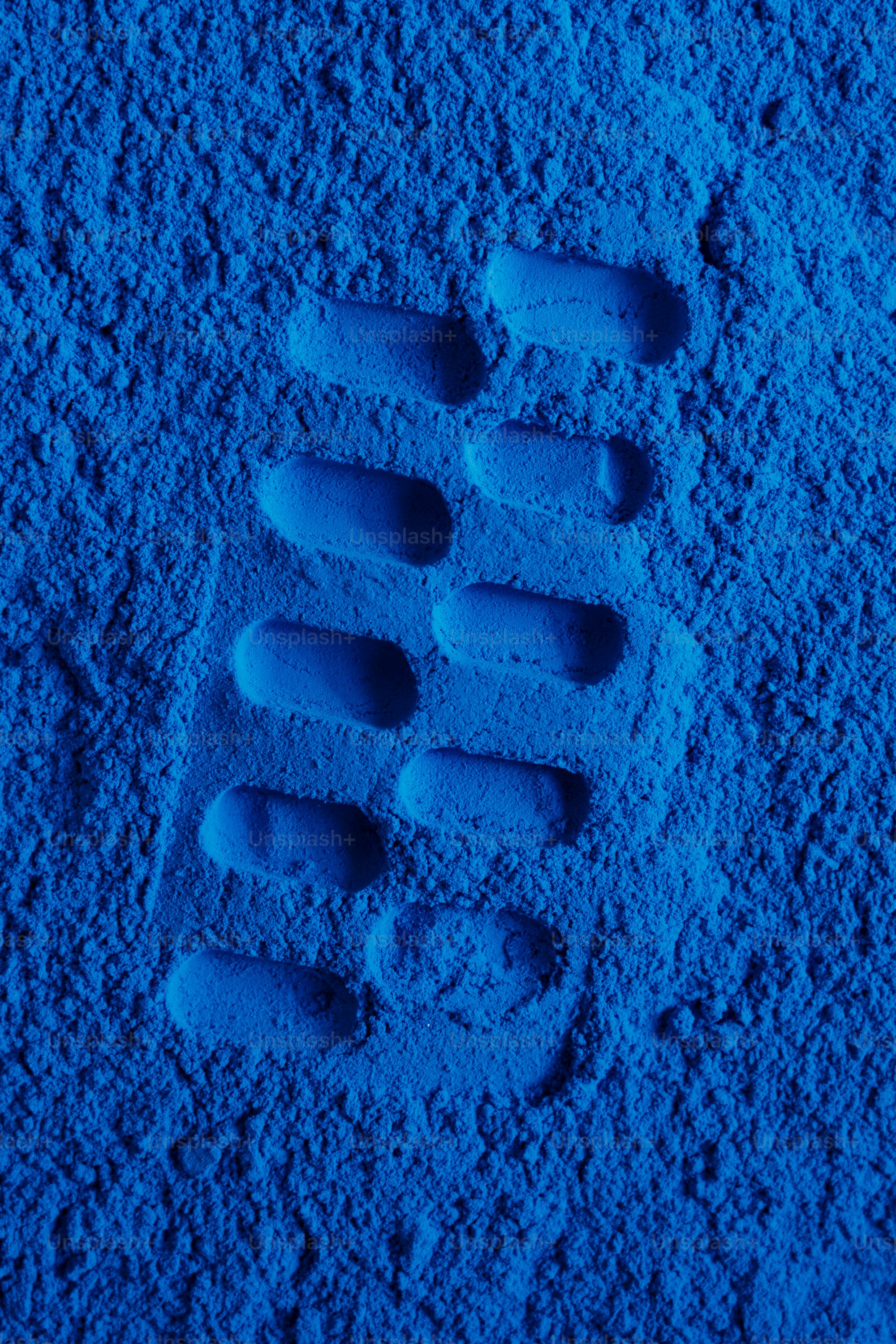 A shoe print pressed into blue powder