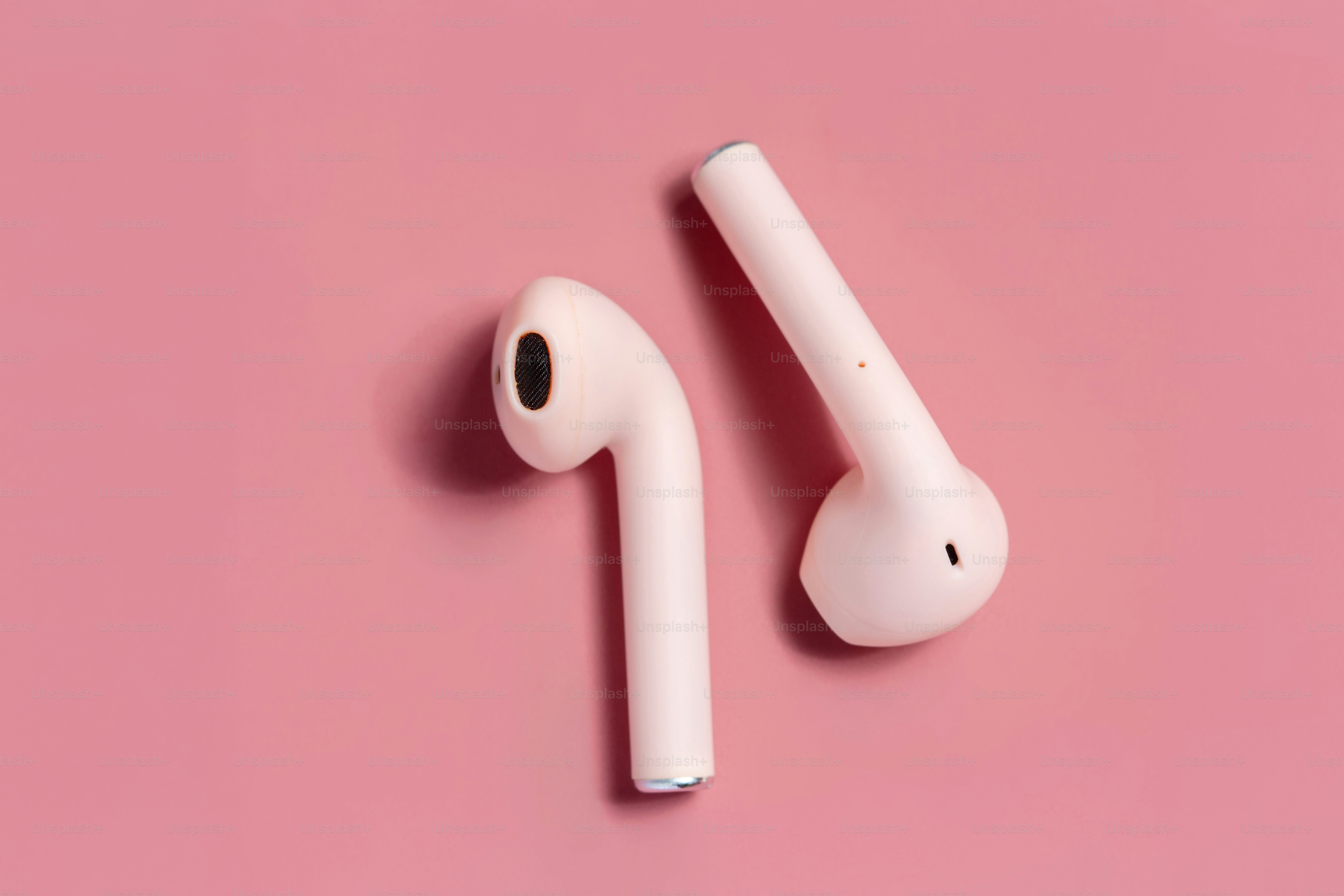 Due auricolari wireless bianchi su sfondo rosa