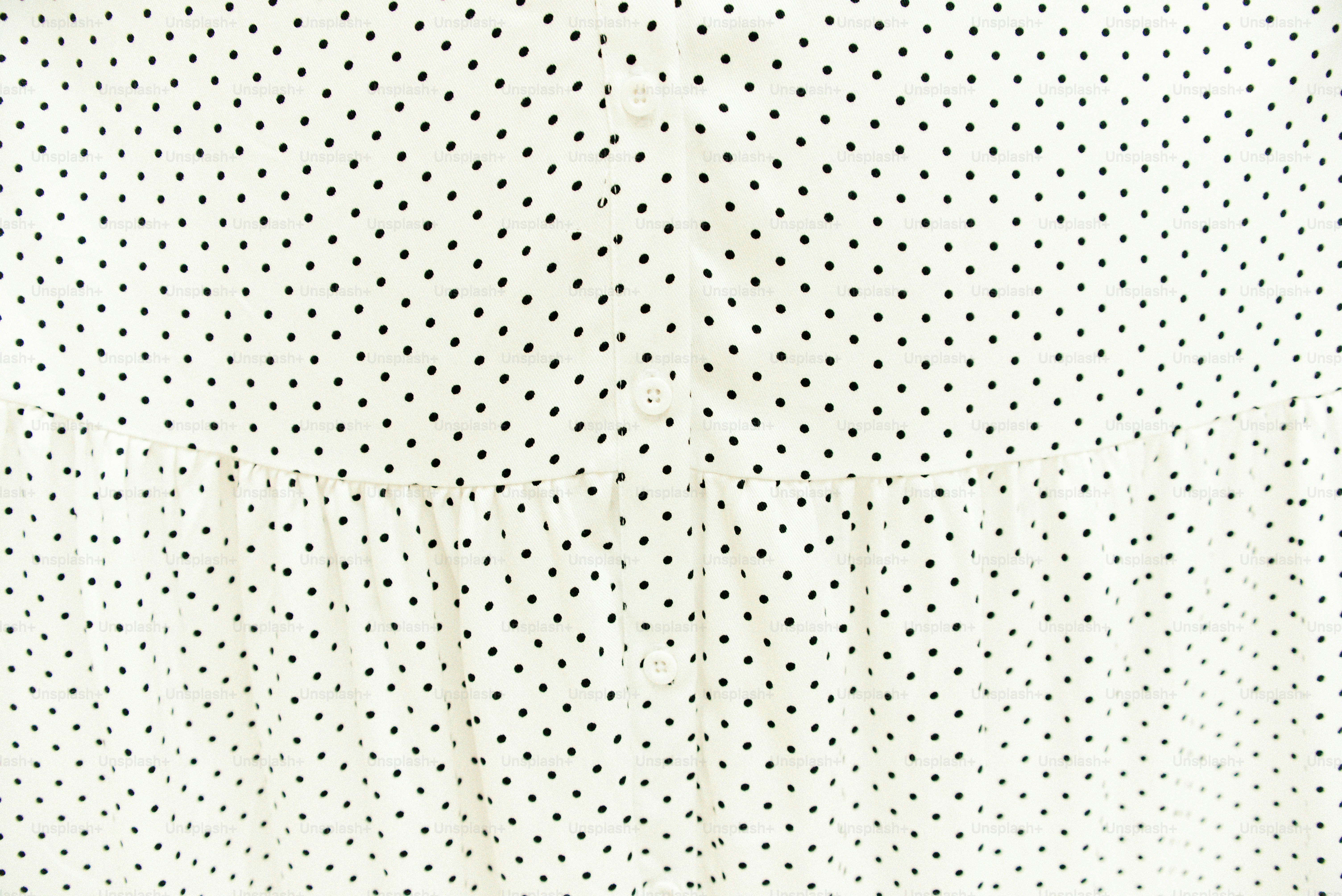 Weißer Stoff mit einem kleinen dunklen Punktmuster