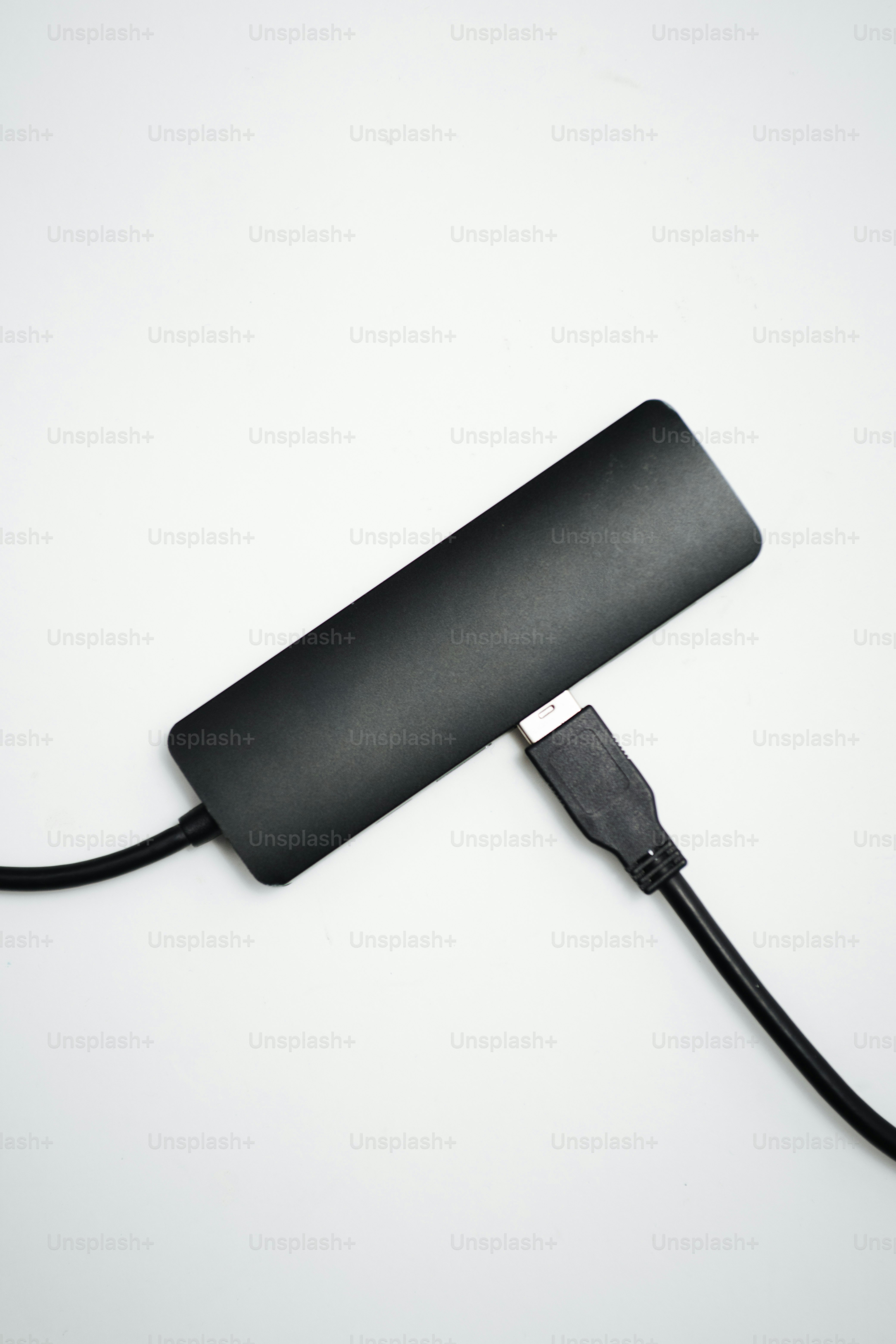 Black usb hub connected to a cable on white background