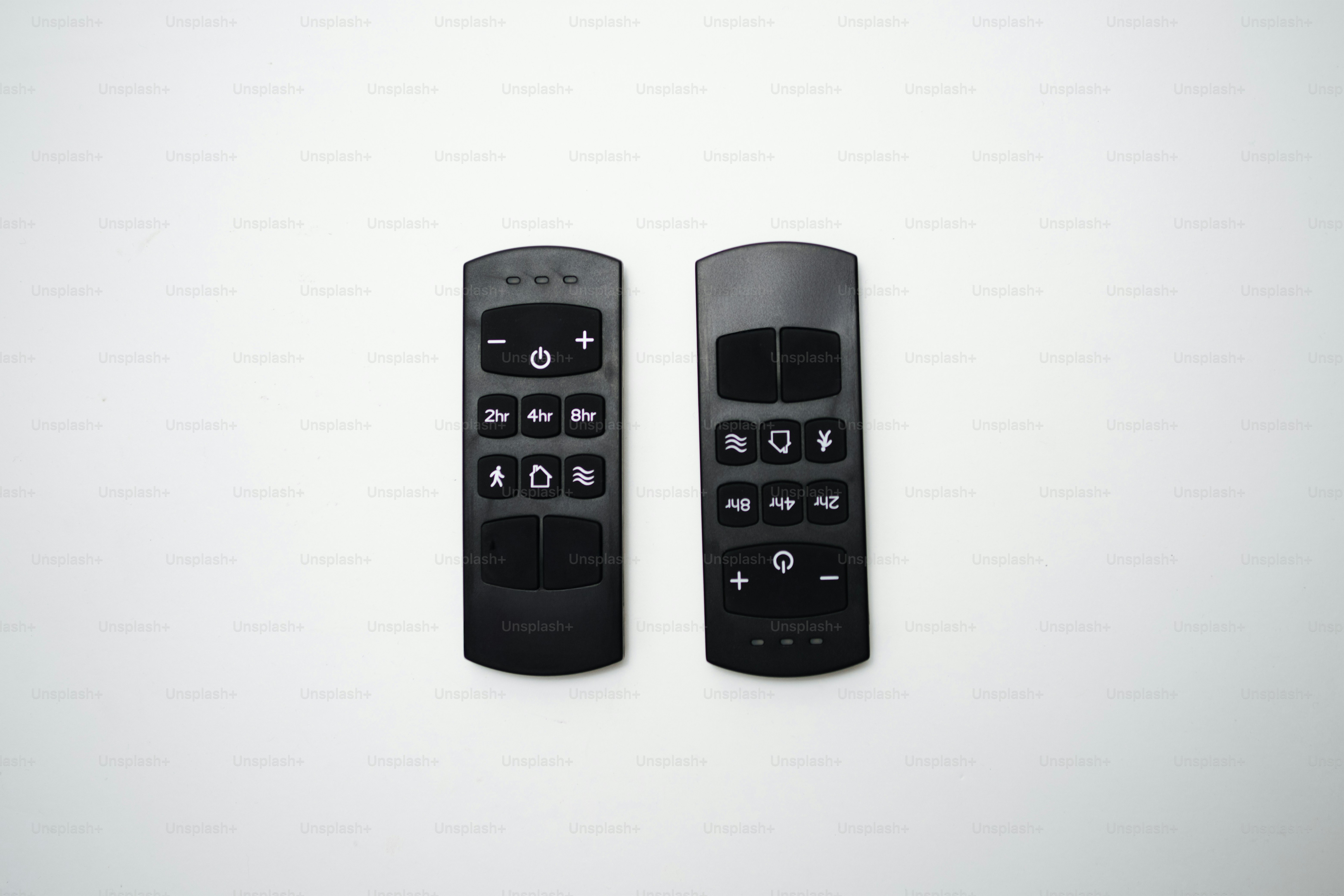 白い背景に黒いリモコンが二つ
