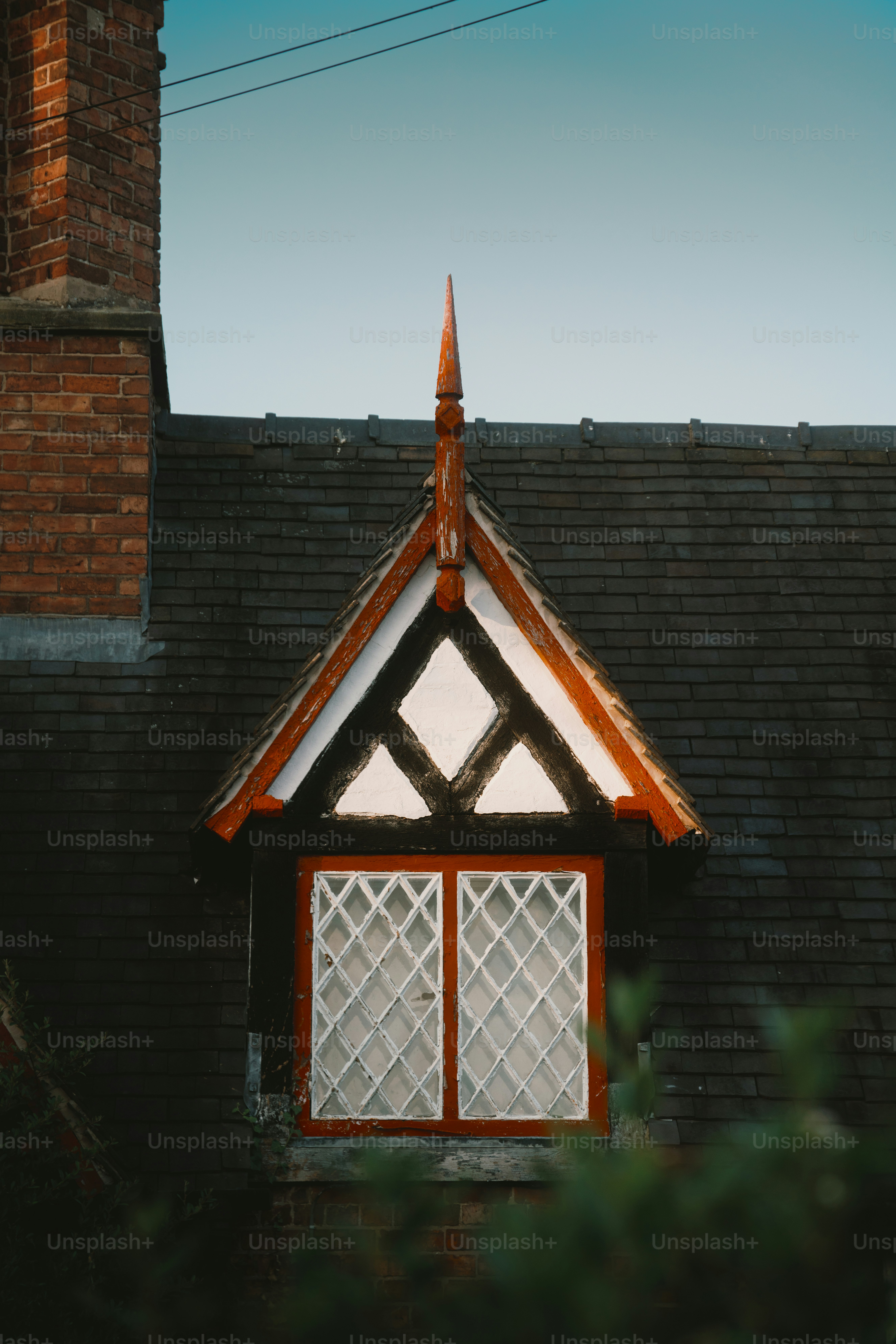 Tudor style dormer window on a dark roof.