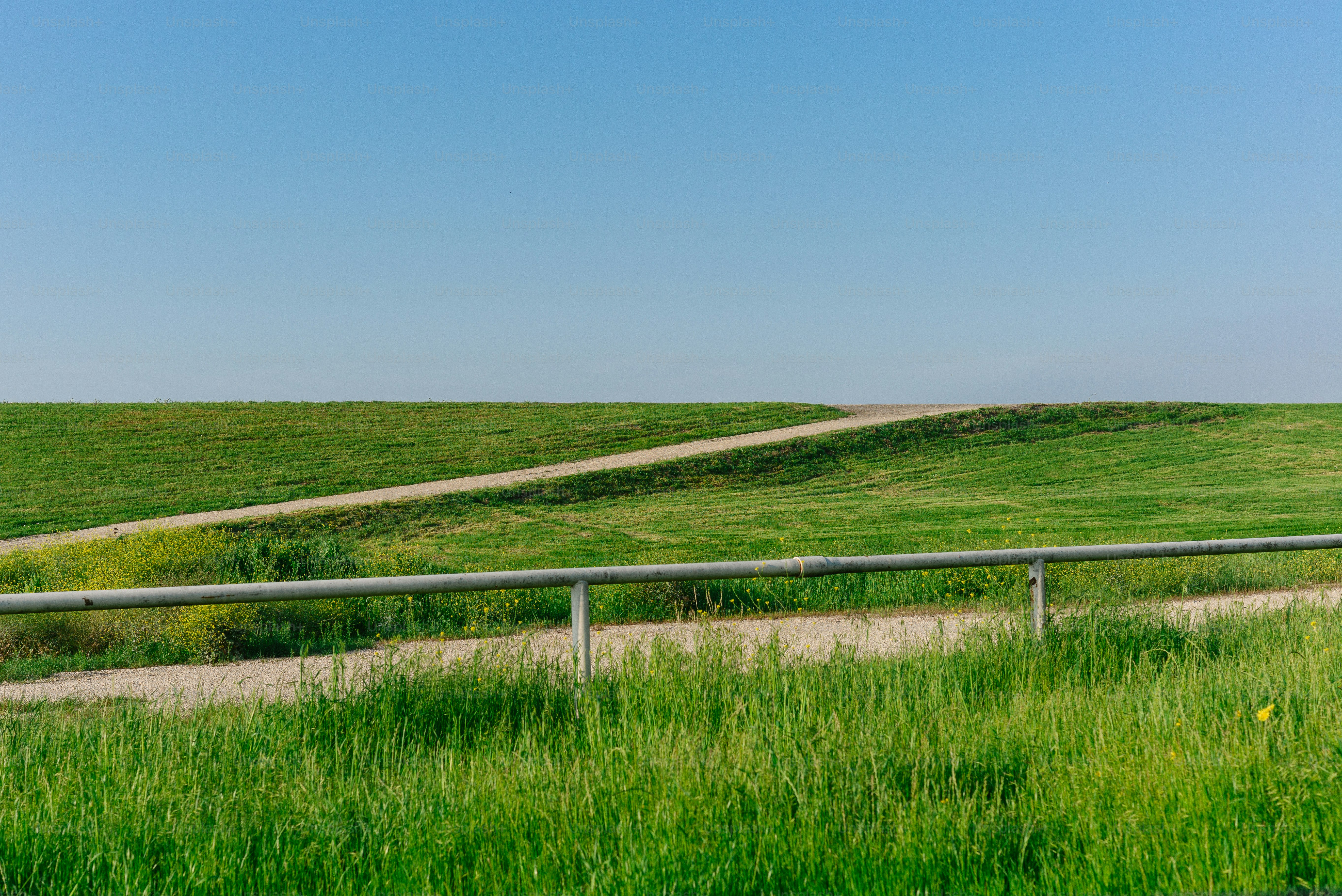 Grassy hill with a path and metal railing