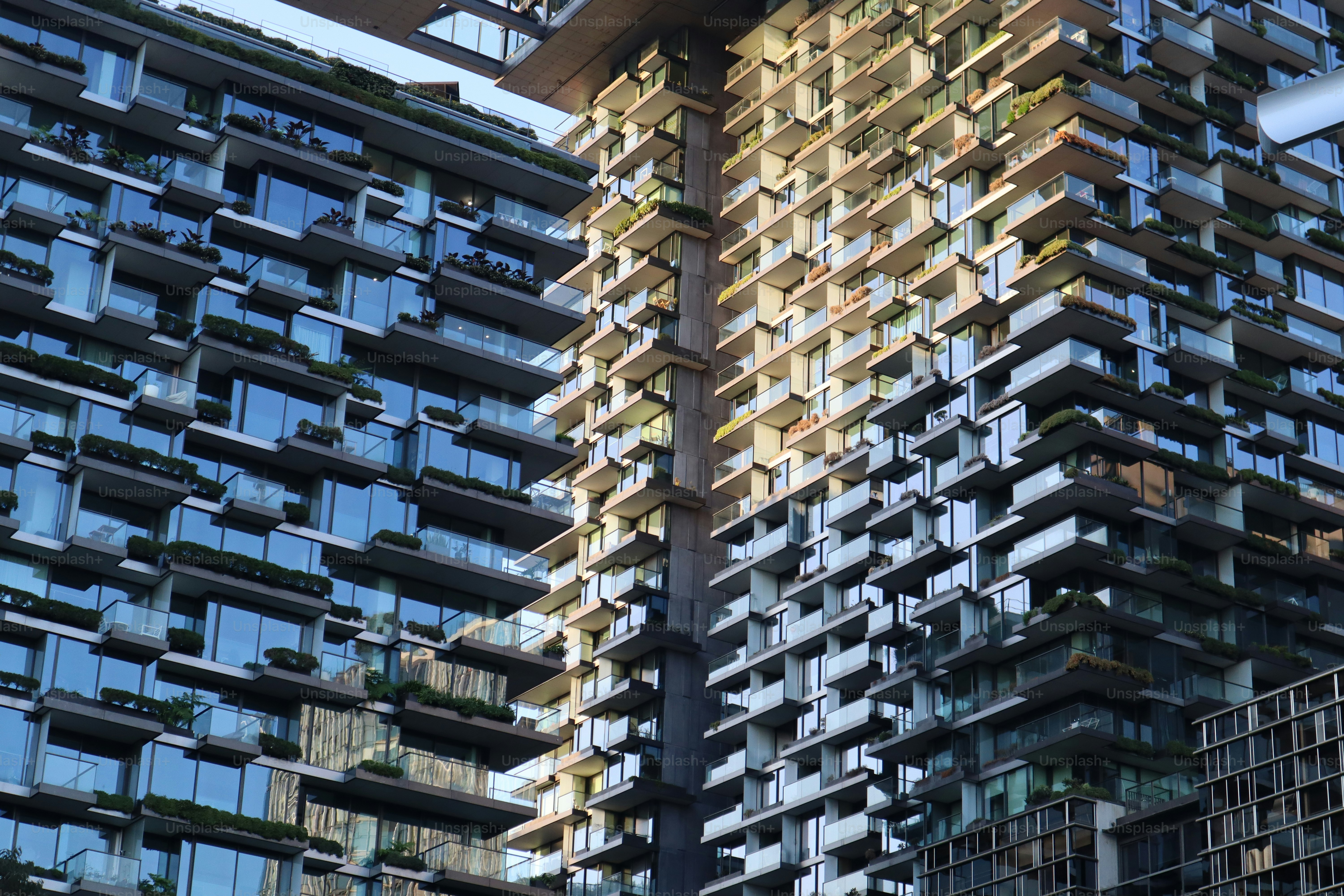 Modern apartment buildings with balconies and reflective windows.