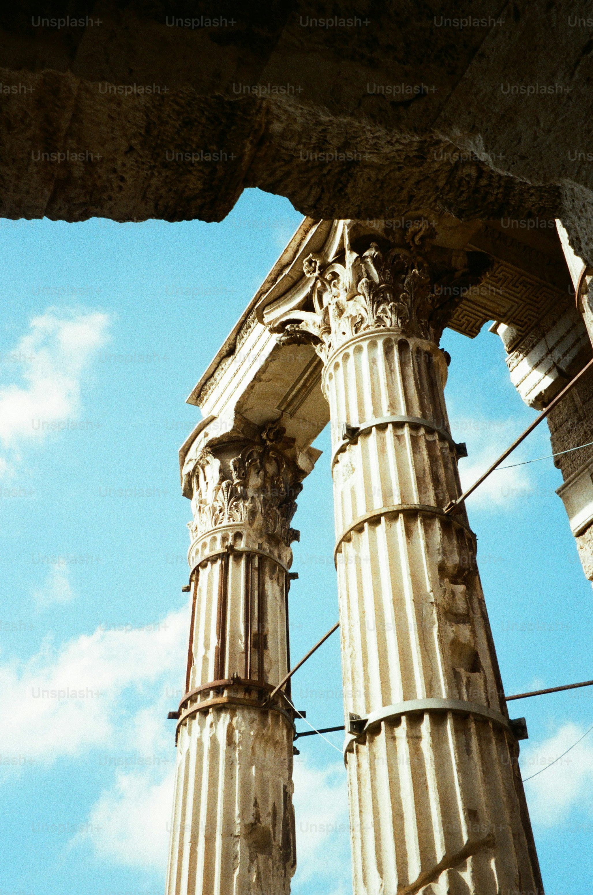 Ancient roman columns against a bright blue sky