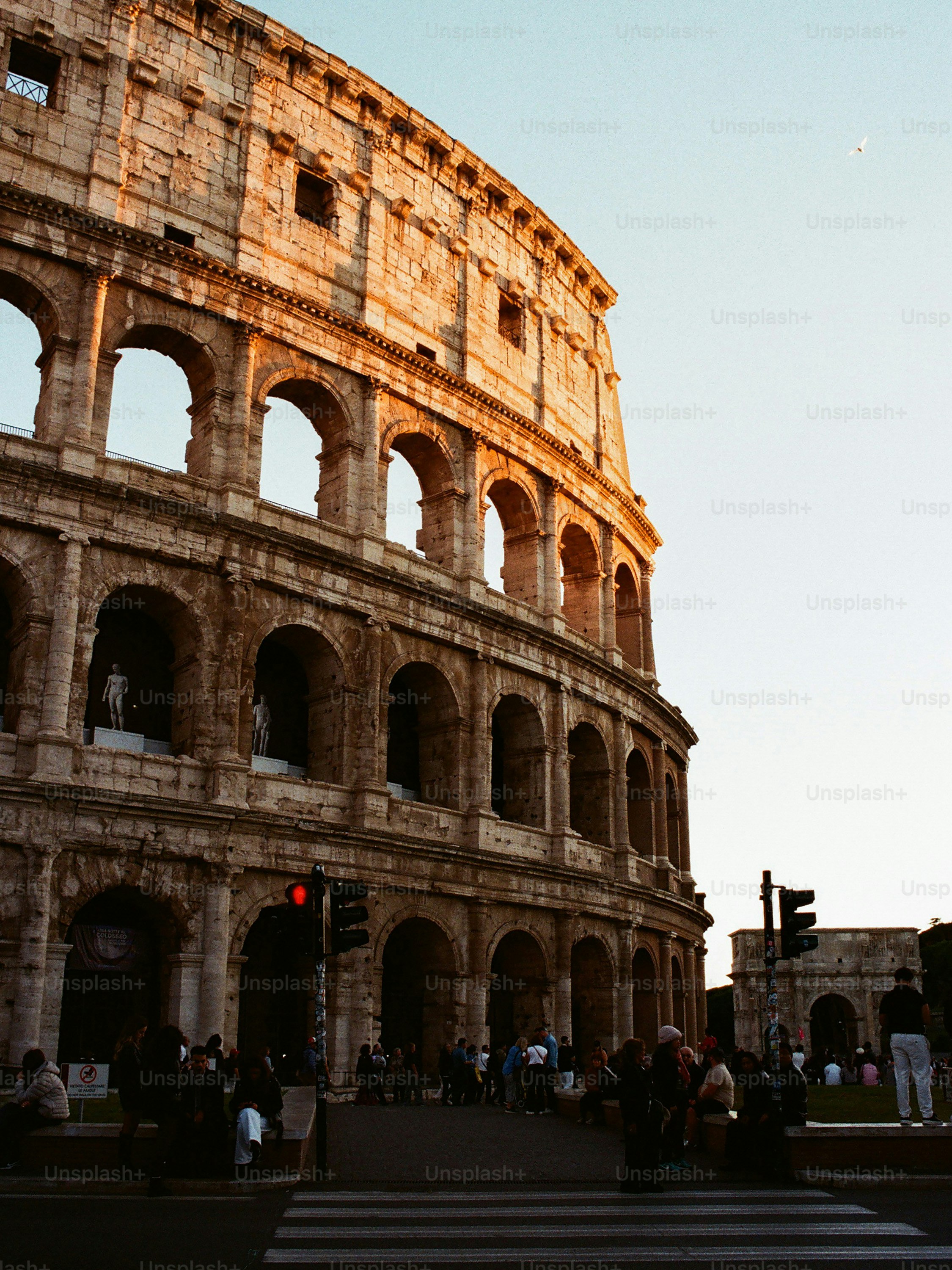 The colosseum in rome bathed in warm sunlight.