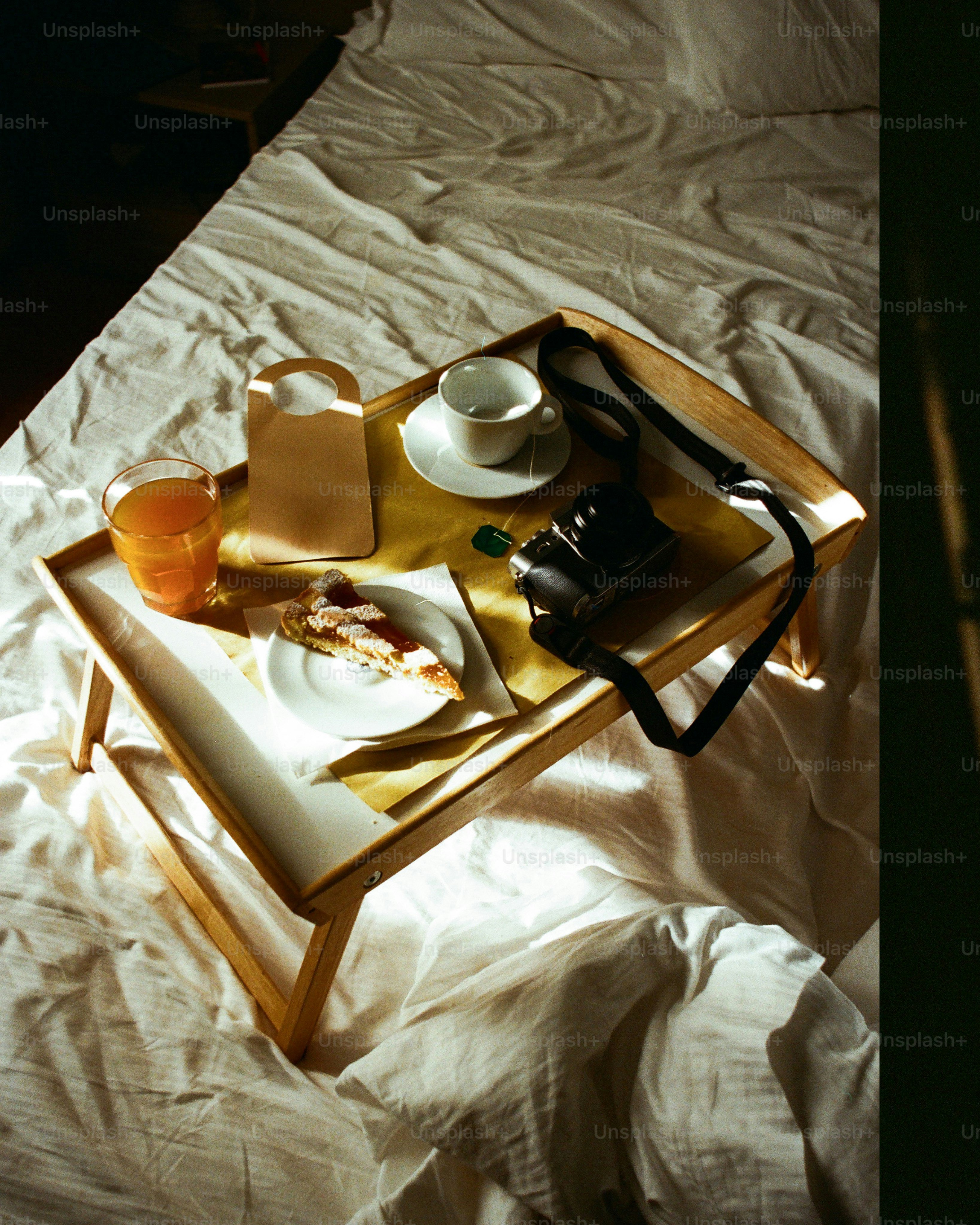 Breakfast tray with food and camera on bed. photo – Camera Image on ...