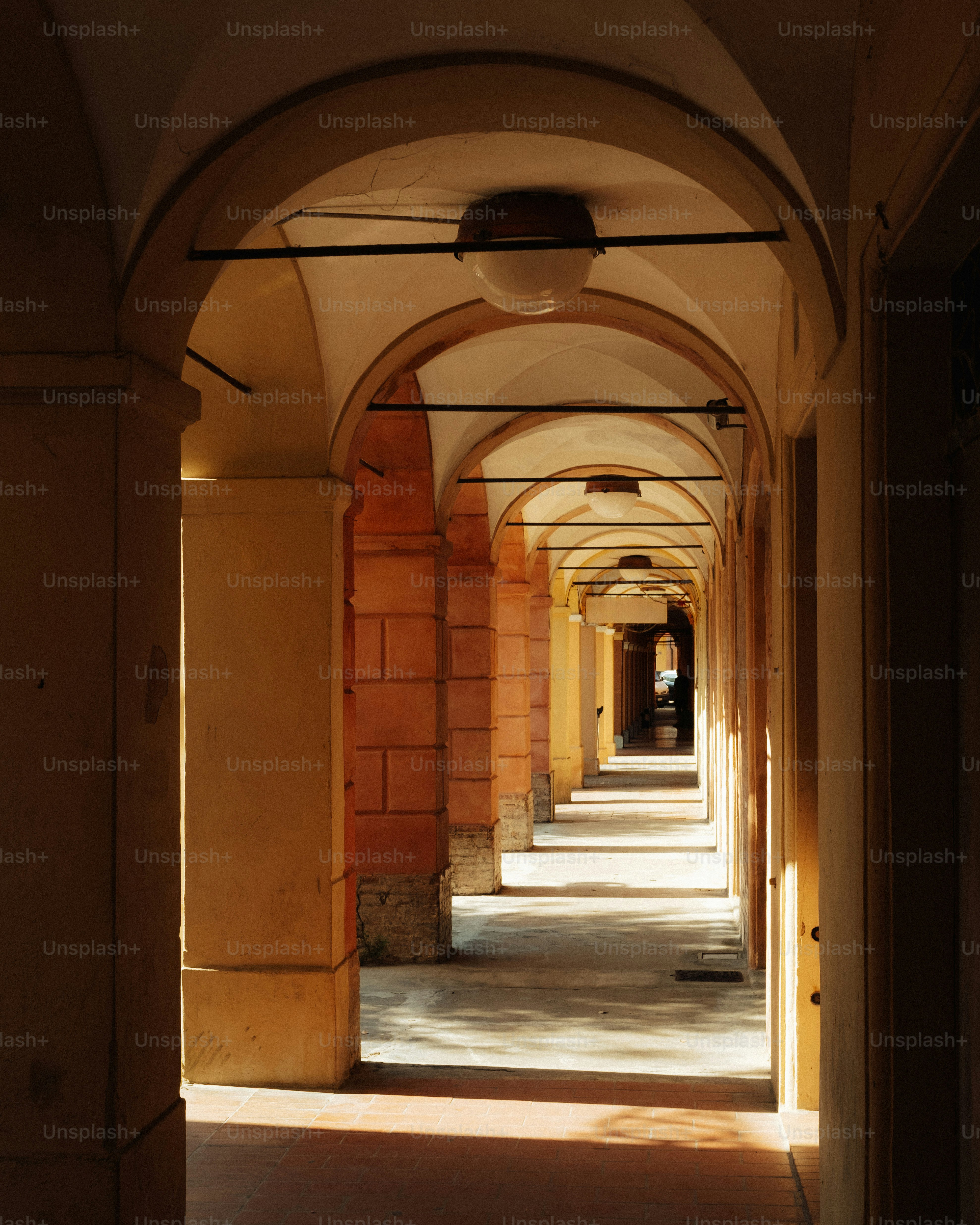 Arched walkway with sunlight and shadows