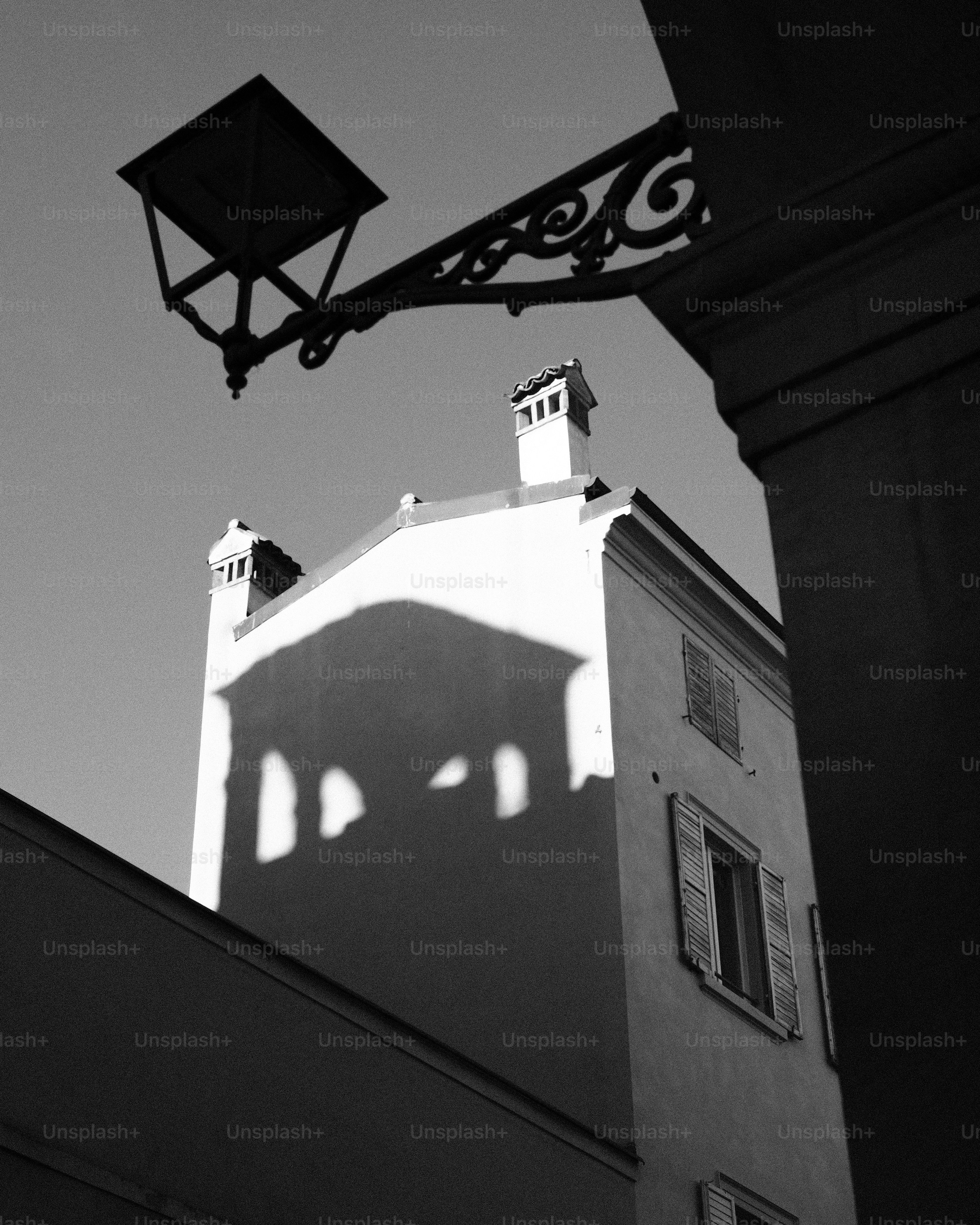 Old street lamp casts shadow on building facade