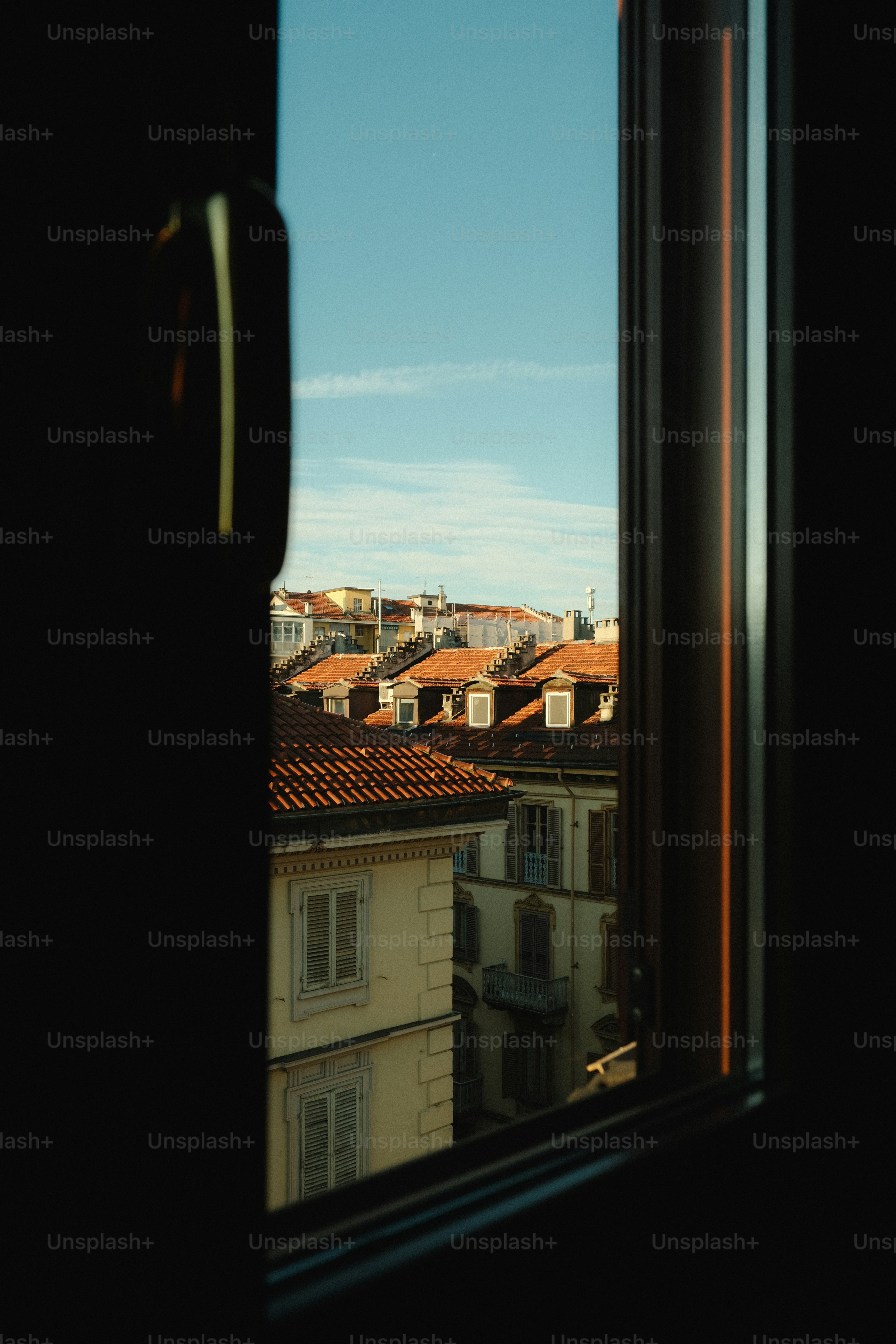 View of rooftops through a window on a clear day photo – Window Image ...