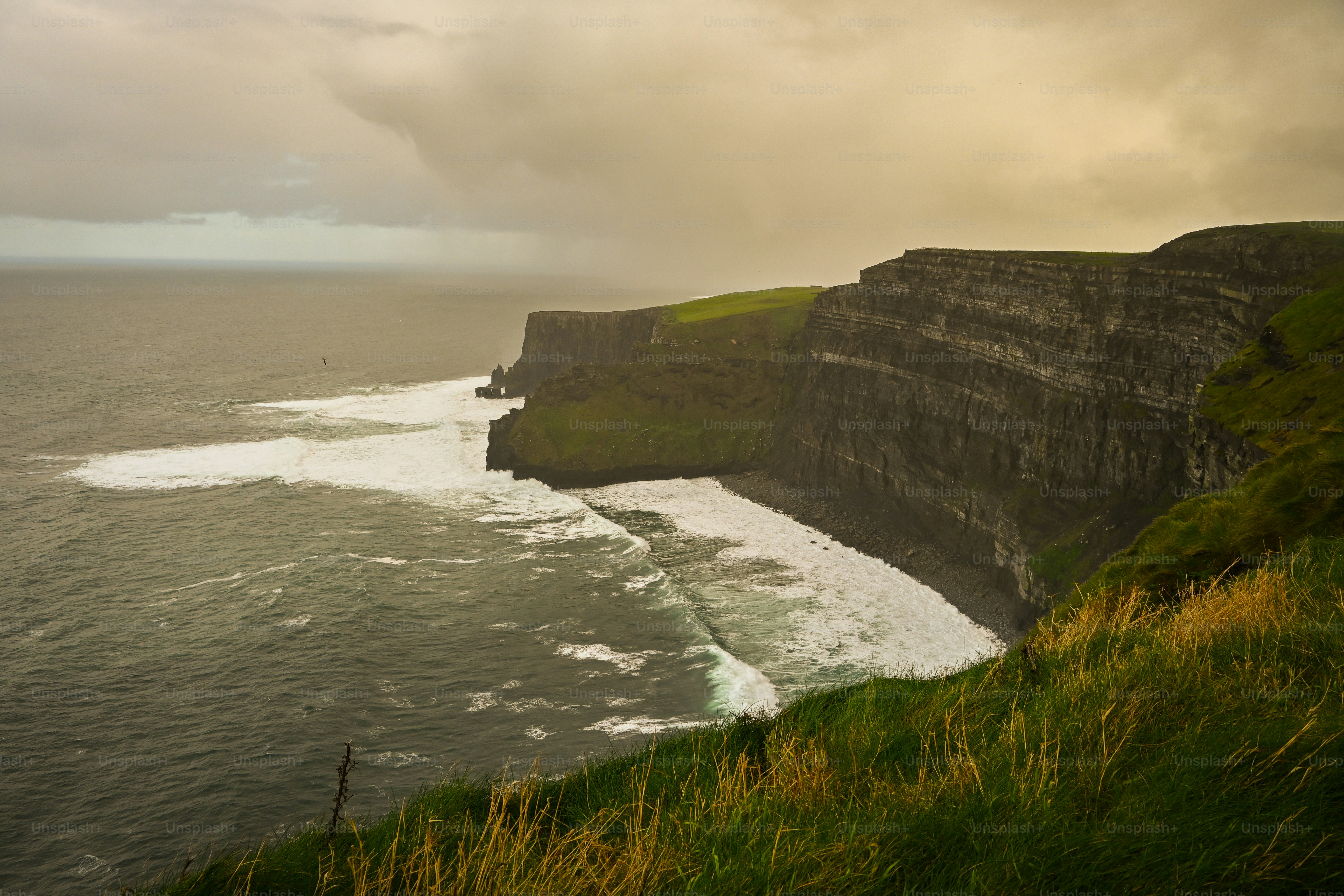 劇的な崖が嵐の空の下で海と接しています。