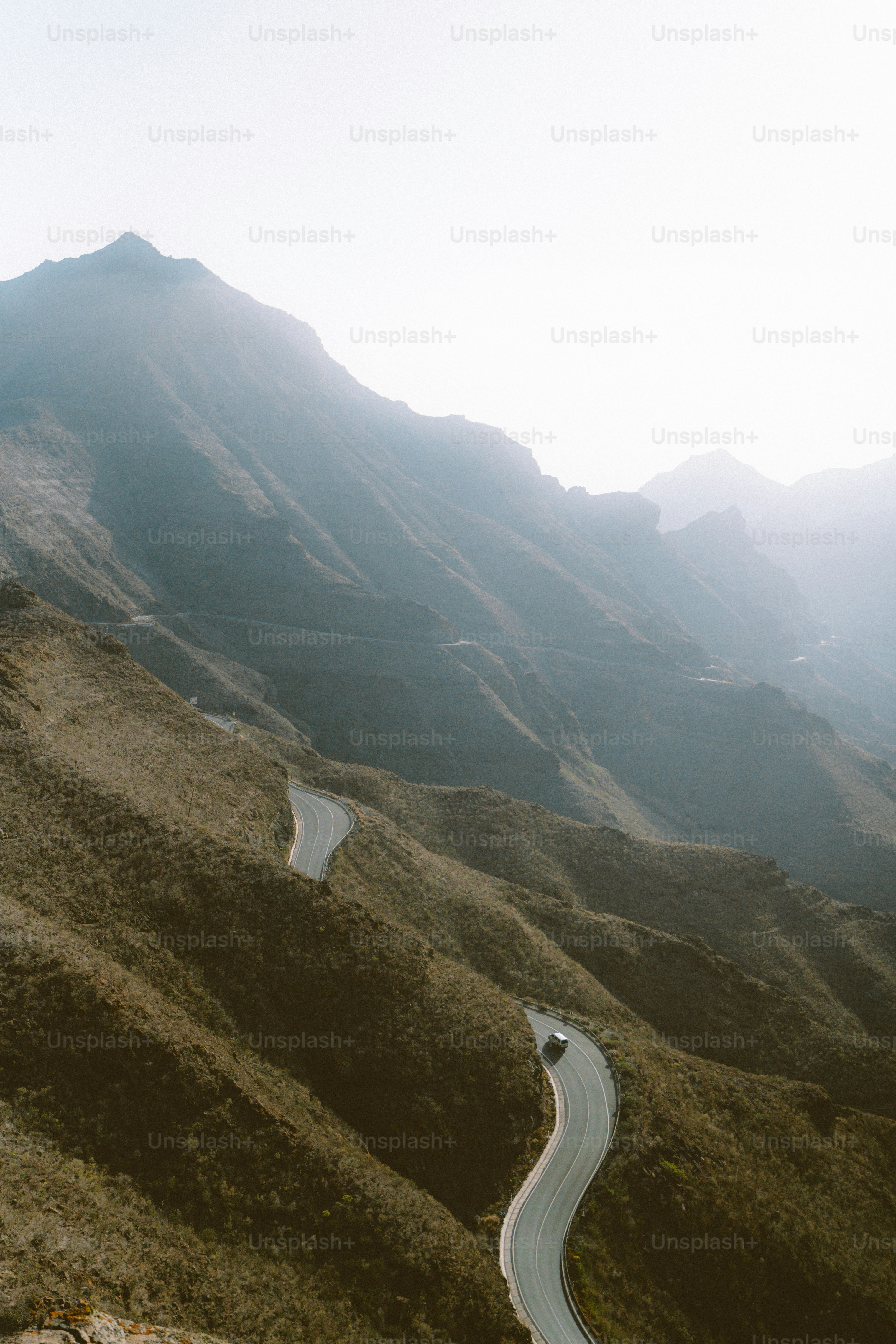 Curving mountain road with a car driving.