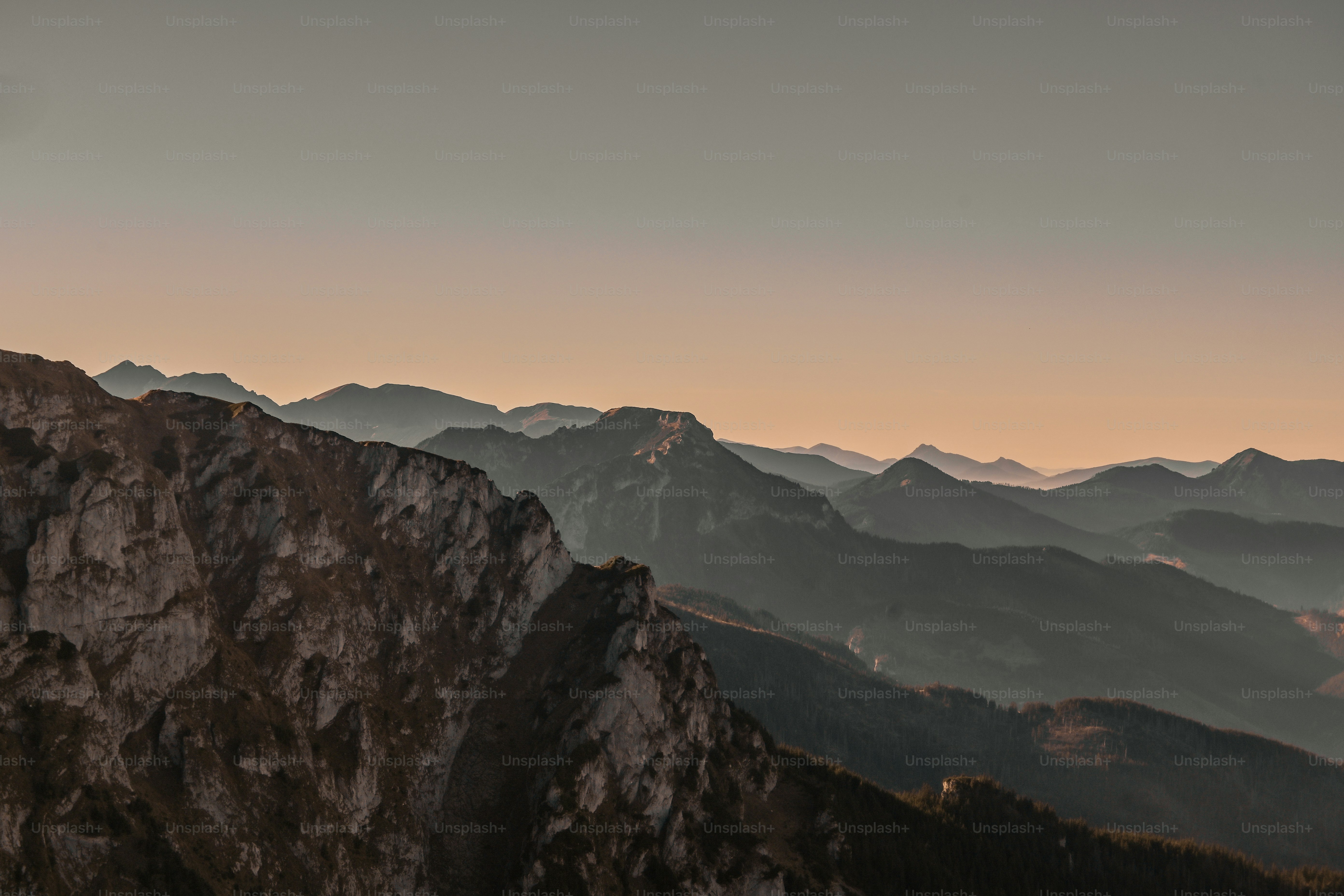 Layered mountain ranges under a soft, hazy sky
