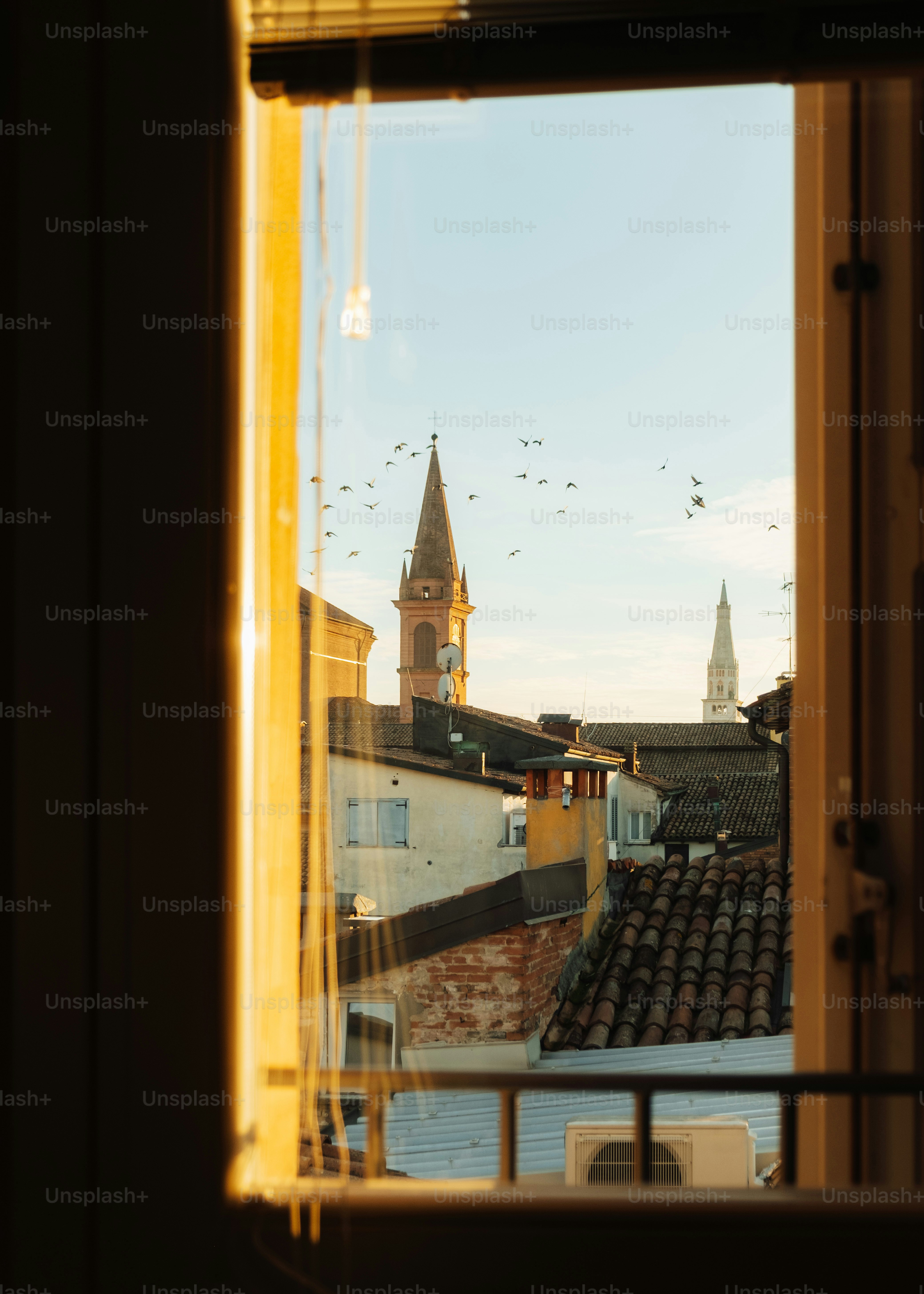 View of church spires through a window at sunset.