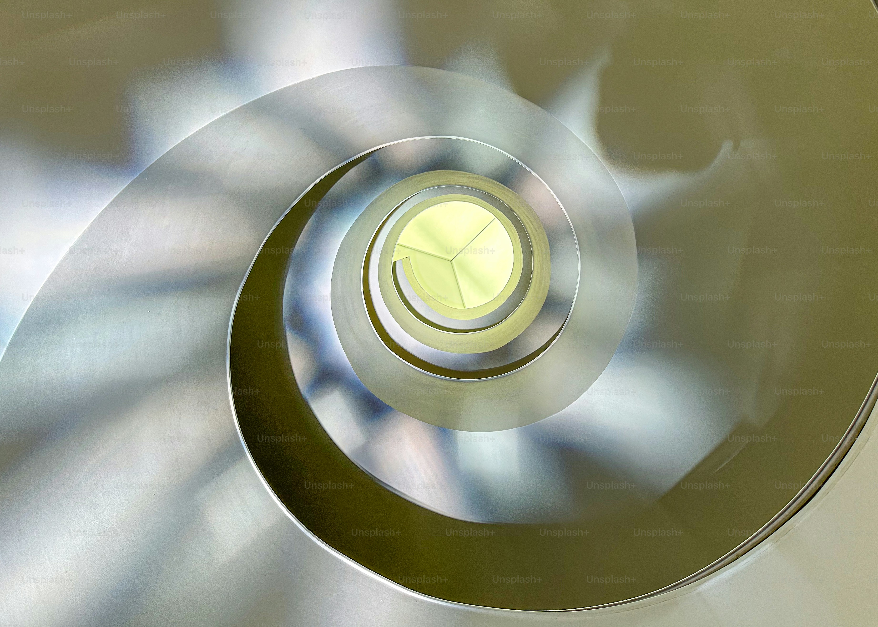 Abstract metallic spiral with bright yellow center.