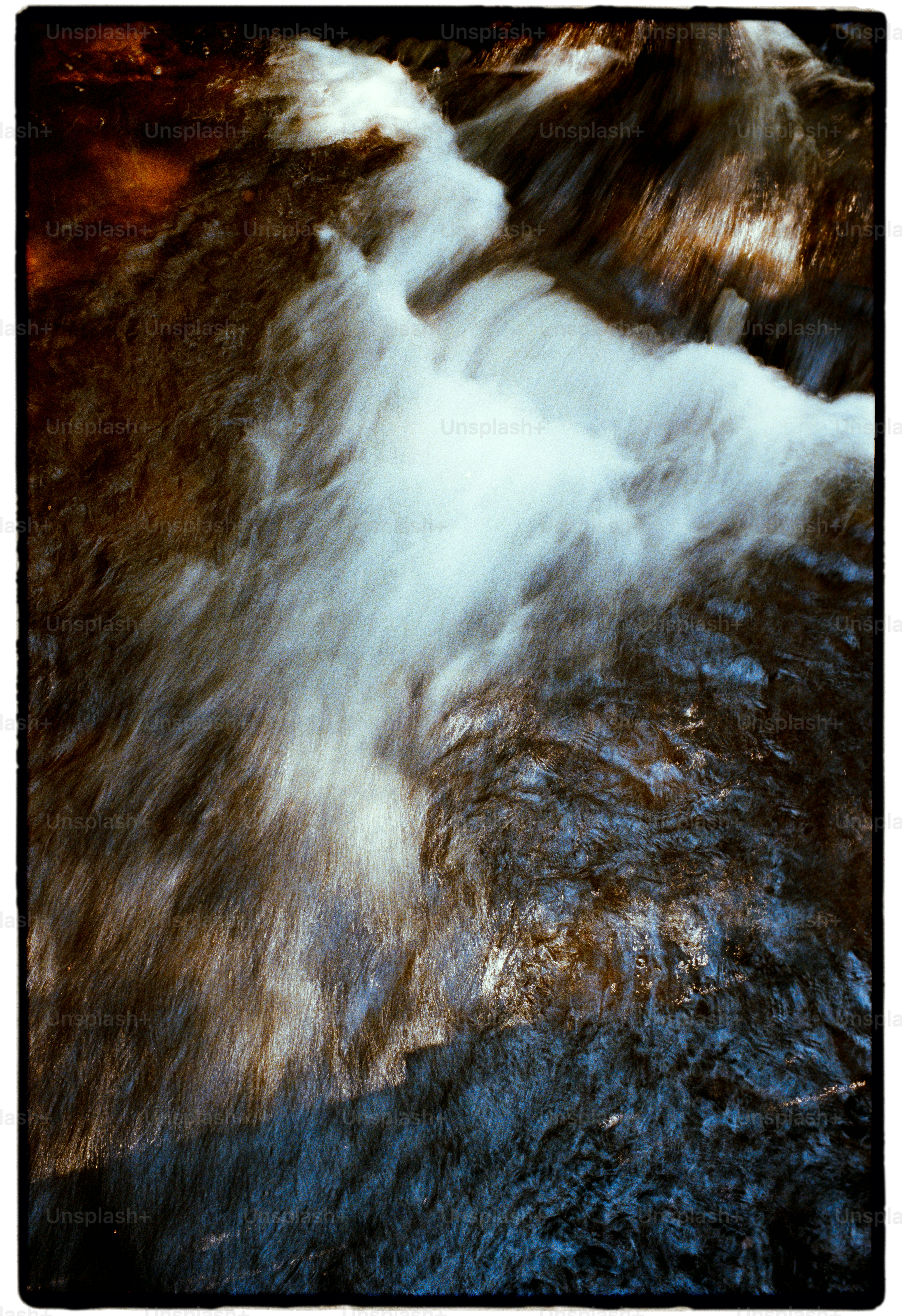 White water rapids flowing over dark rocks. photo – Analog Image on ...