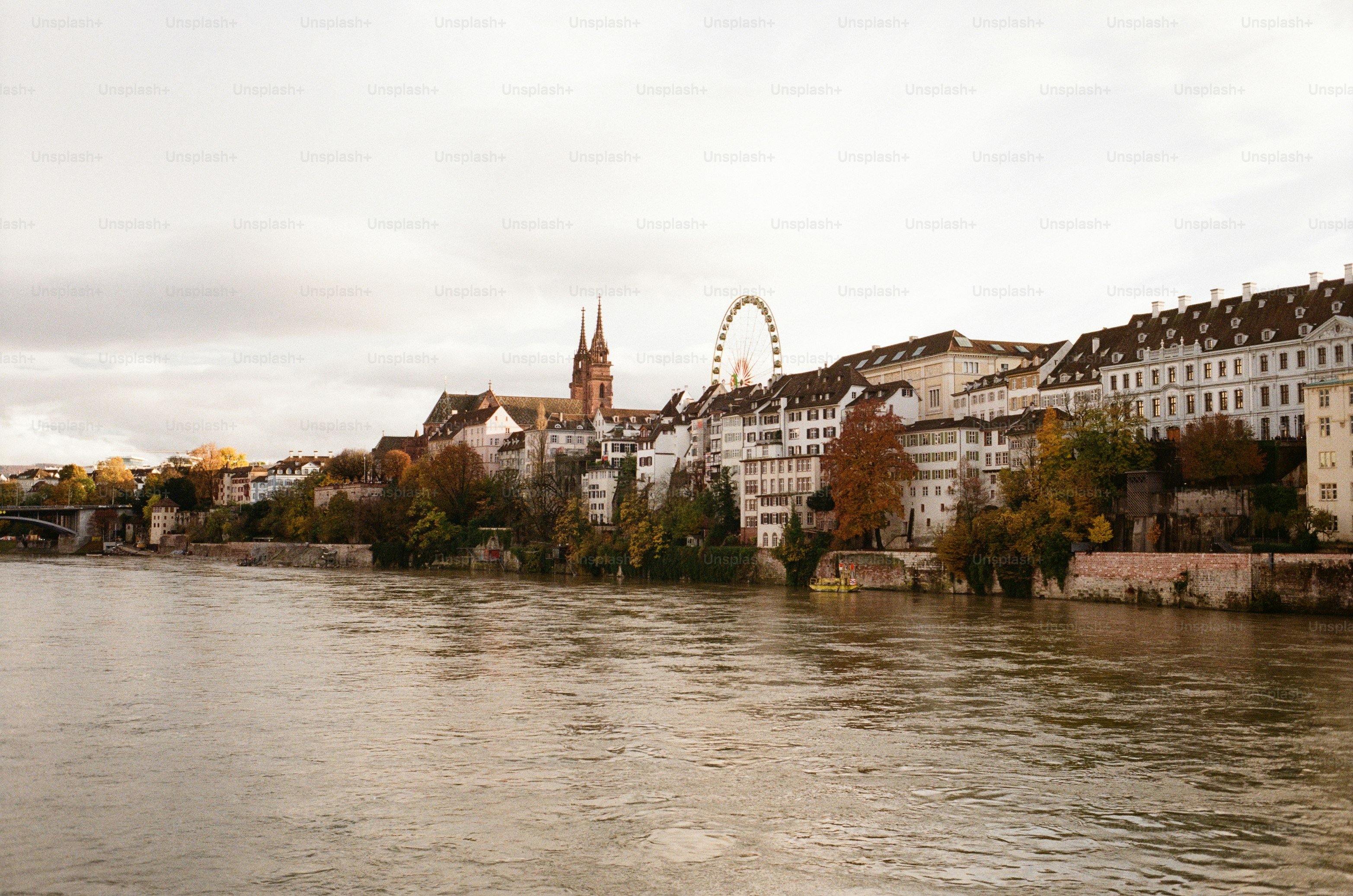 Paysage urbain avec rivière et grande roue sous un ciel nuageux