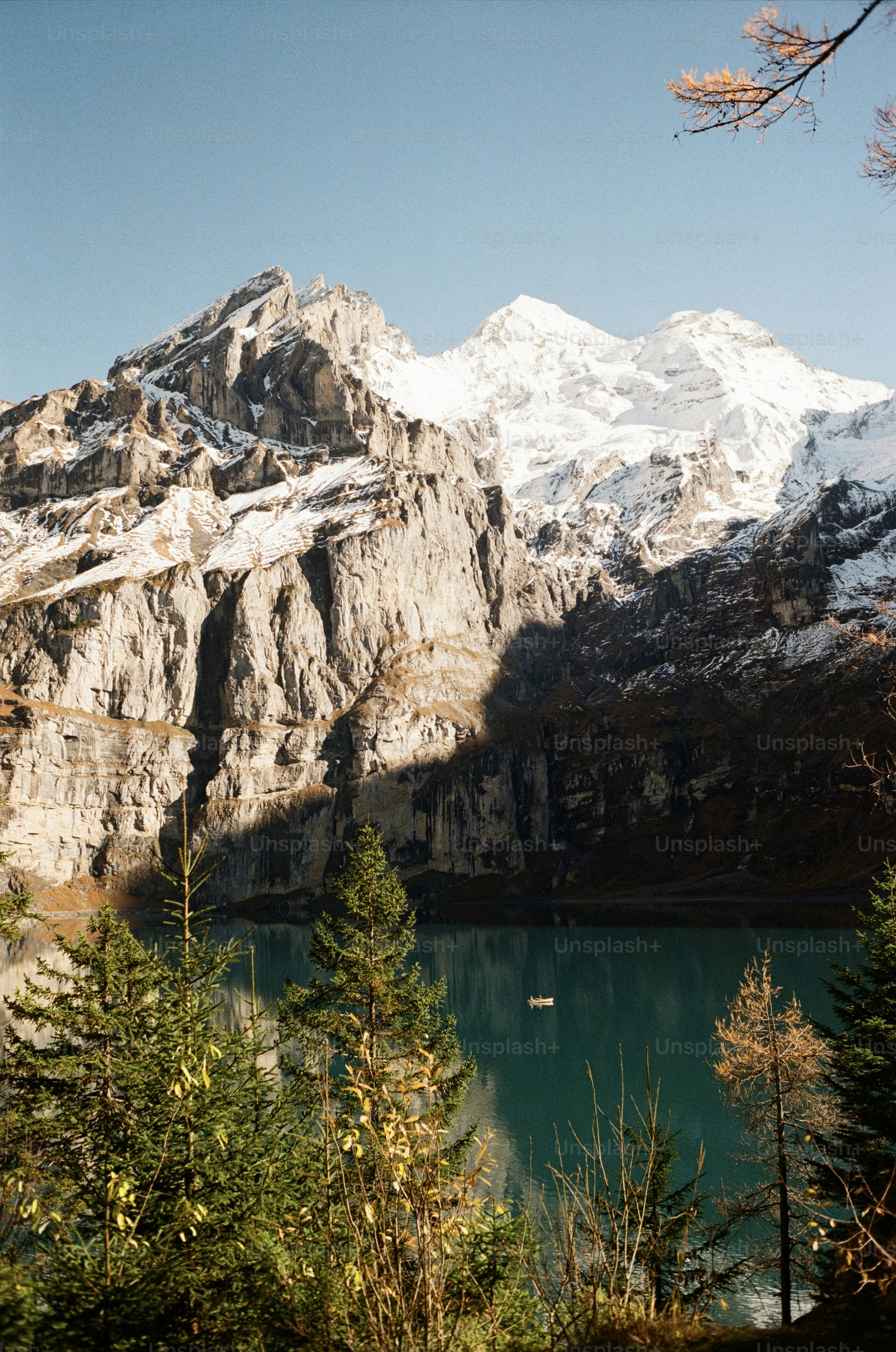 Des montagnes enneigées surplombent un lac turquoise paisible.