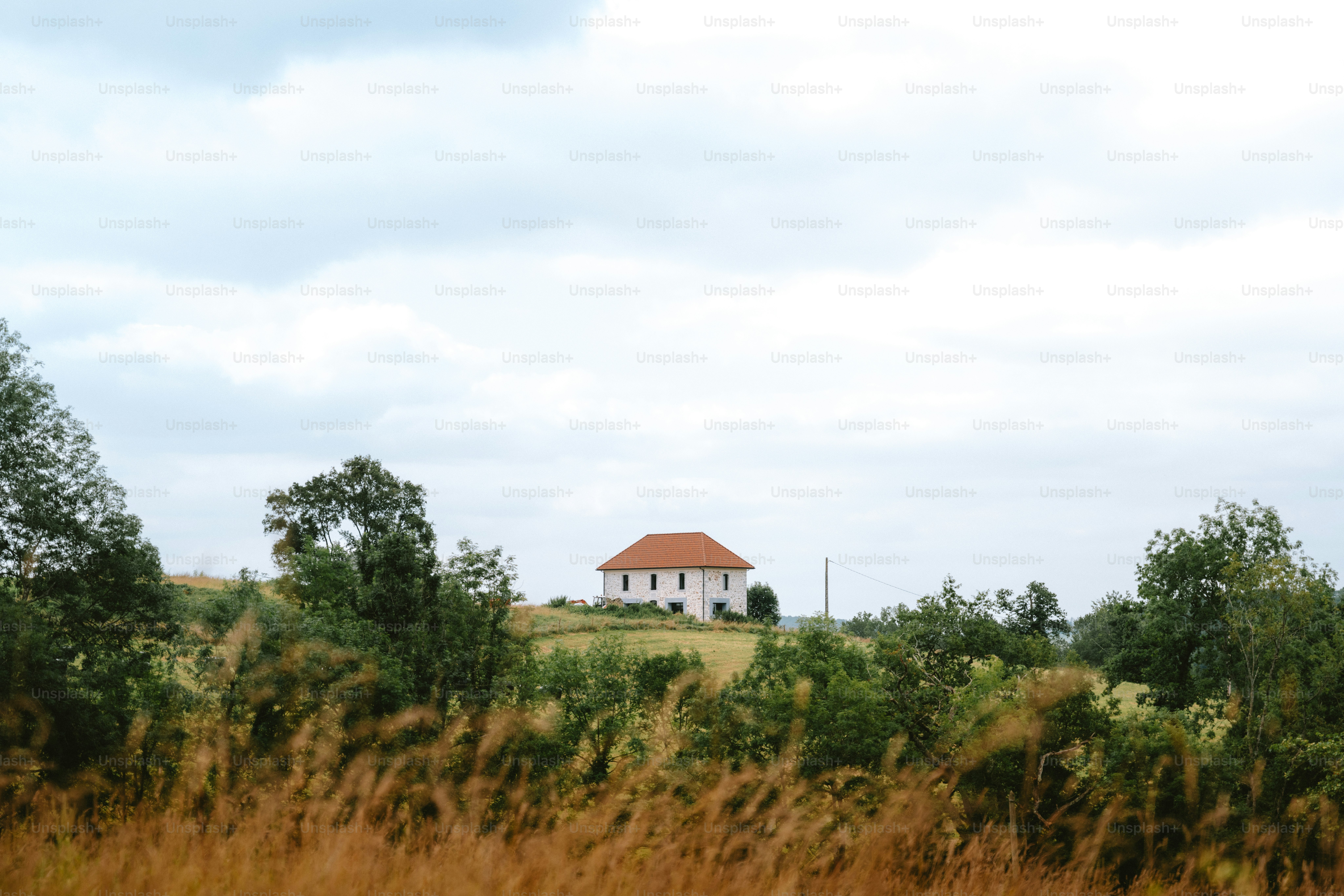Una casa blanca con un tejado naranja en una colina.