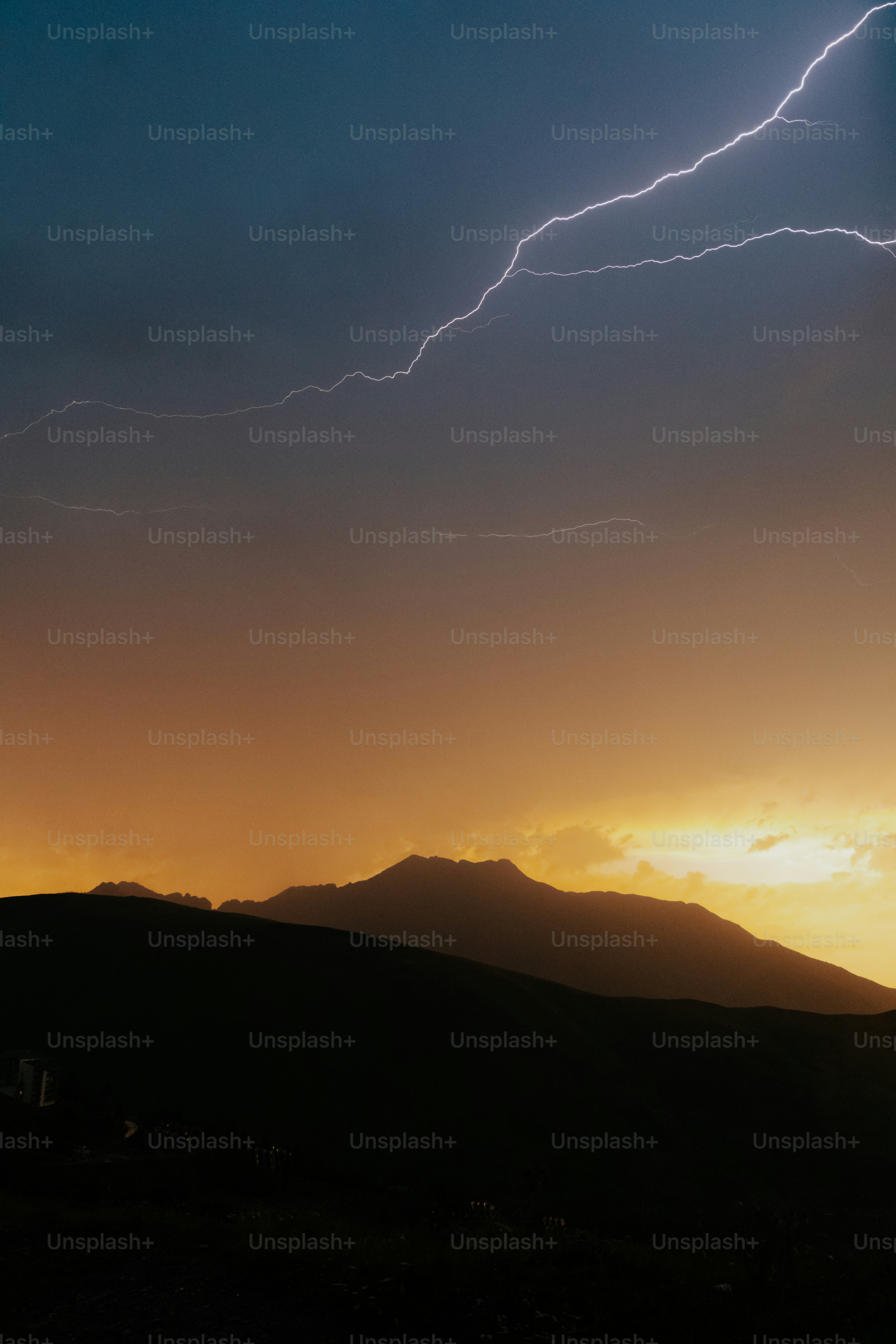 Lightning strikes over silhouetted mountains at sunset. photo – Sunset ...