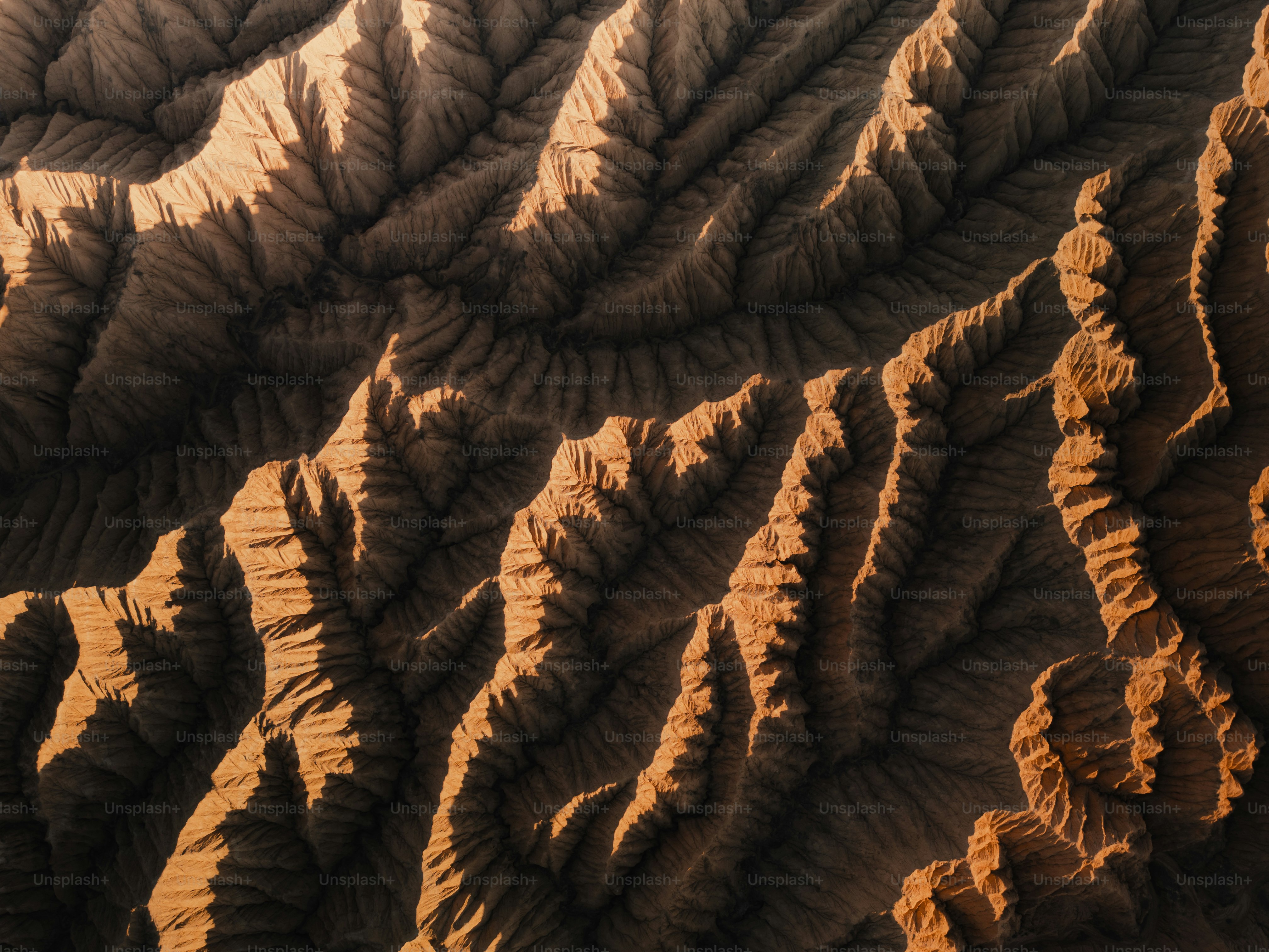 Aerial view of arid mountain ridges with dramatic shadows photo ...