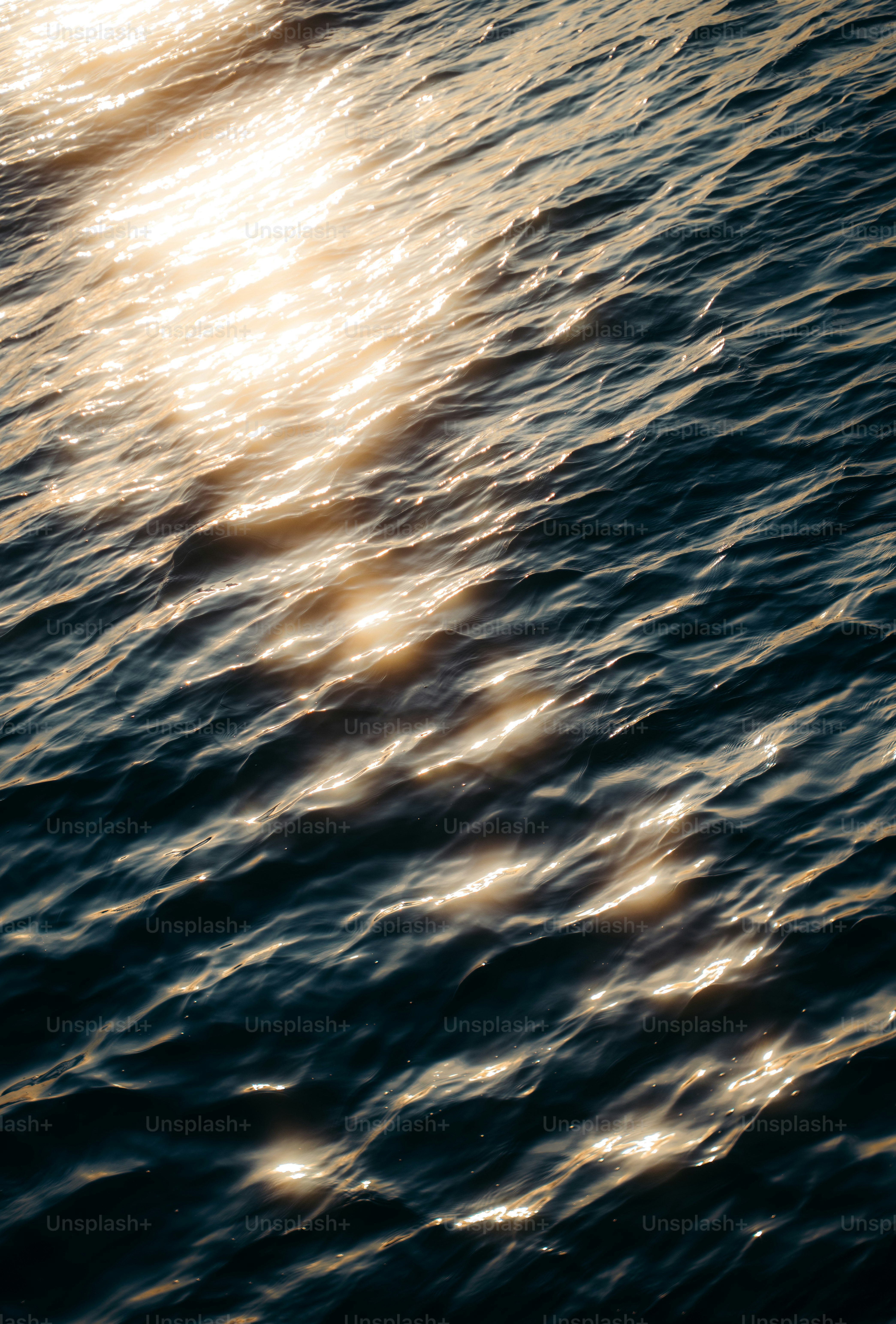 La lumière du soleil scintille sur les vagues sombres de l’océan