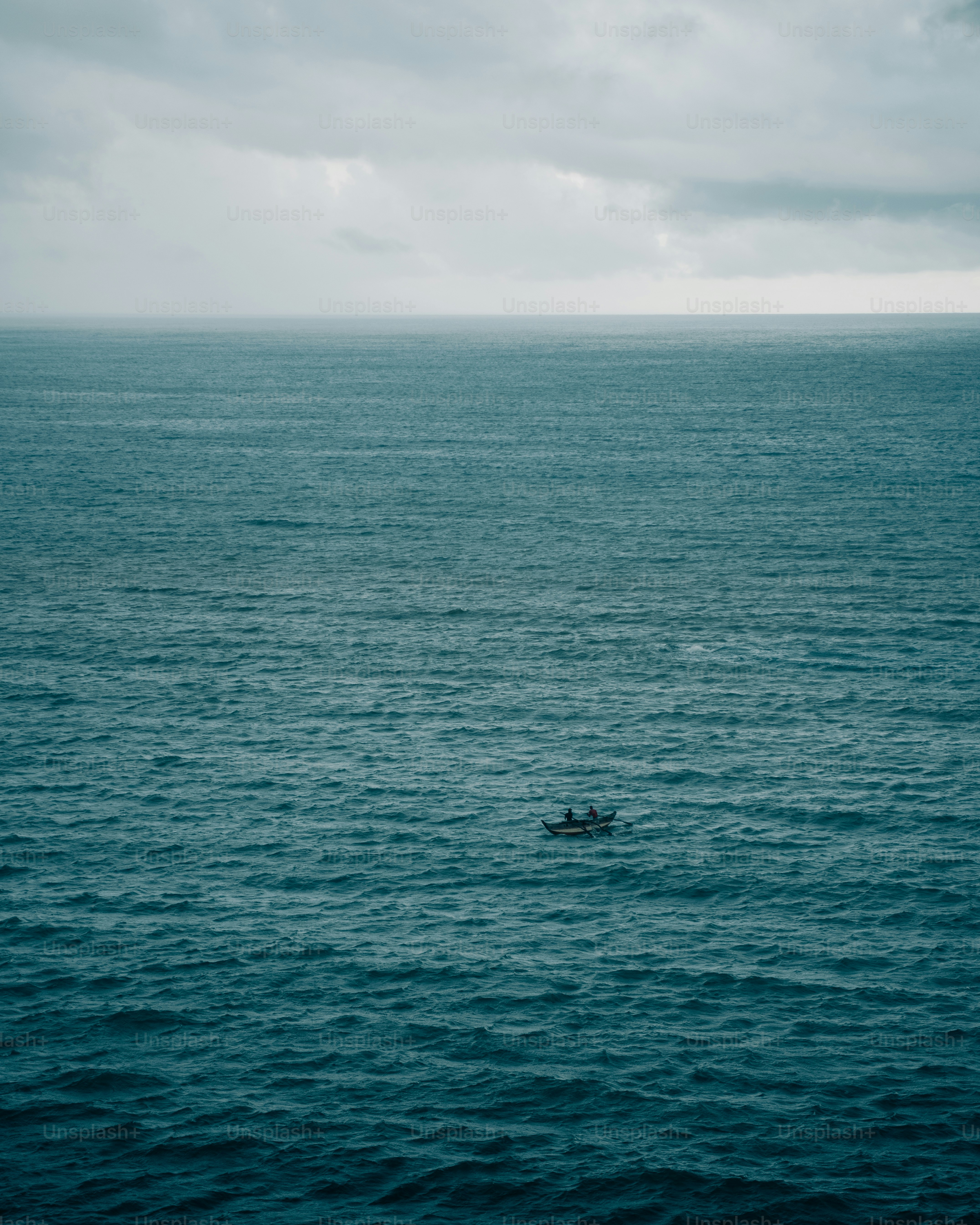 Petit bateau avec des gens sur un vaste océan agité