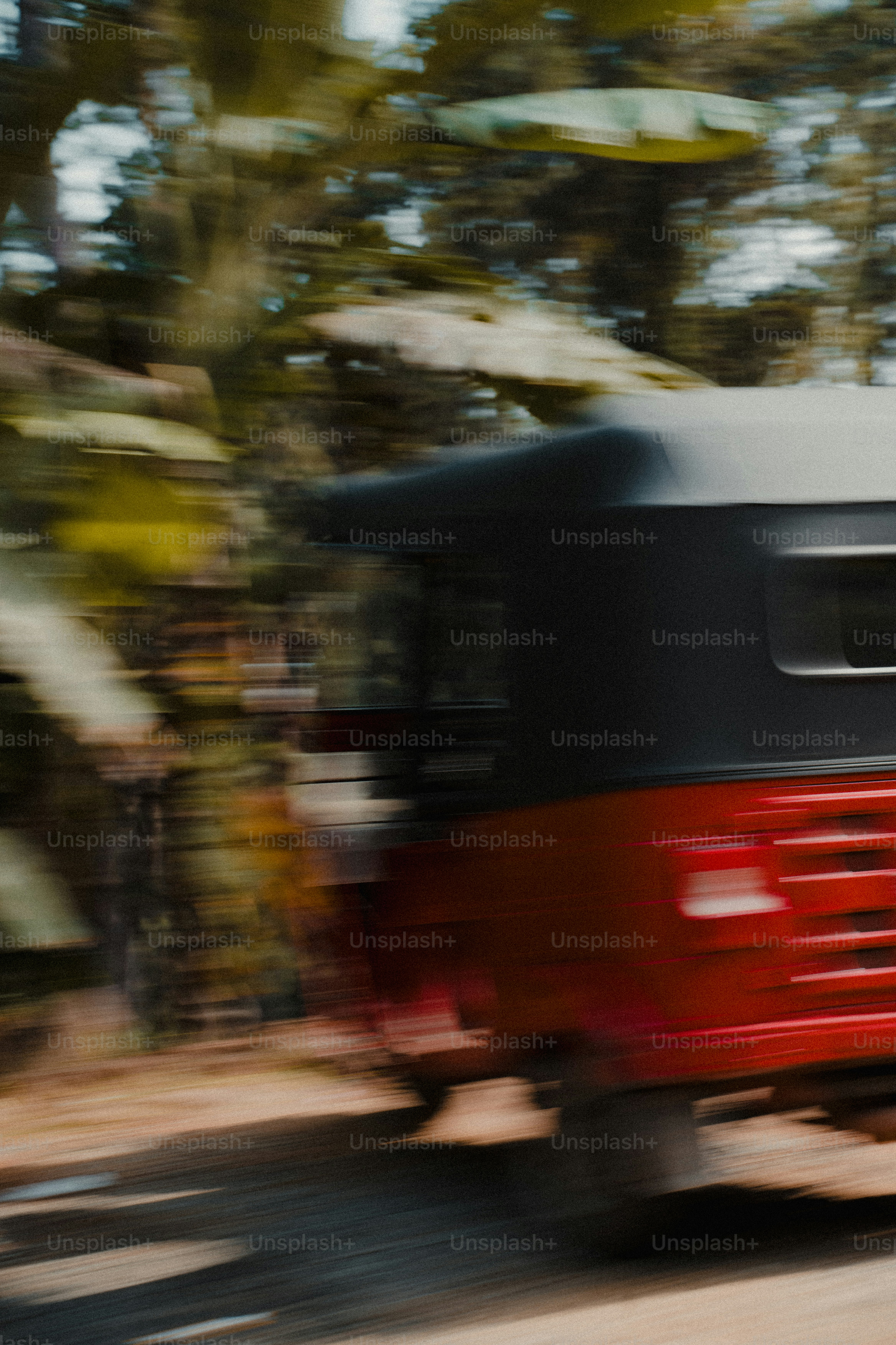 Auto-rickshaw rouge roulant sur un chemin de terre