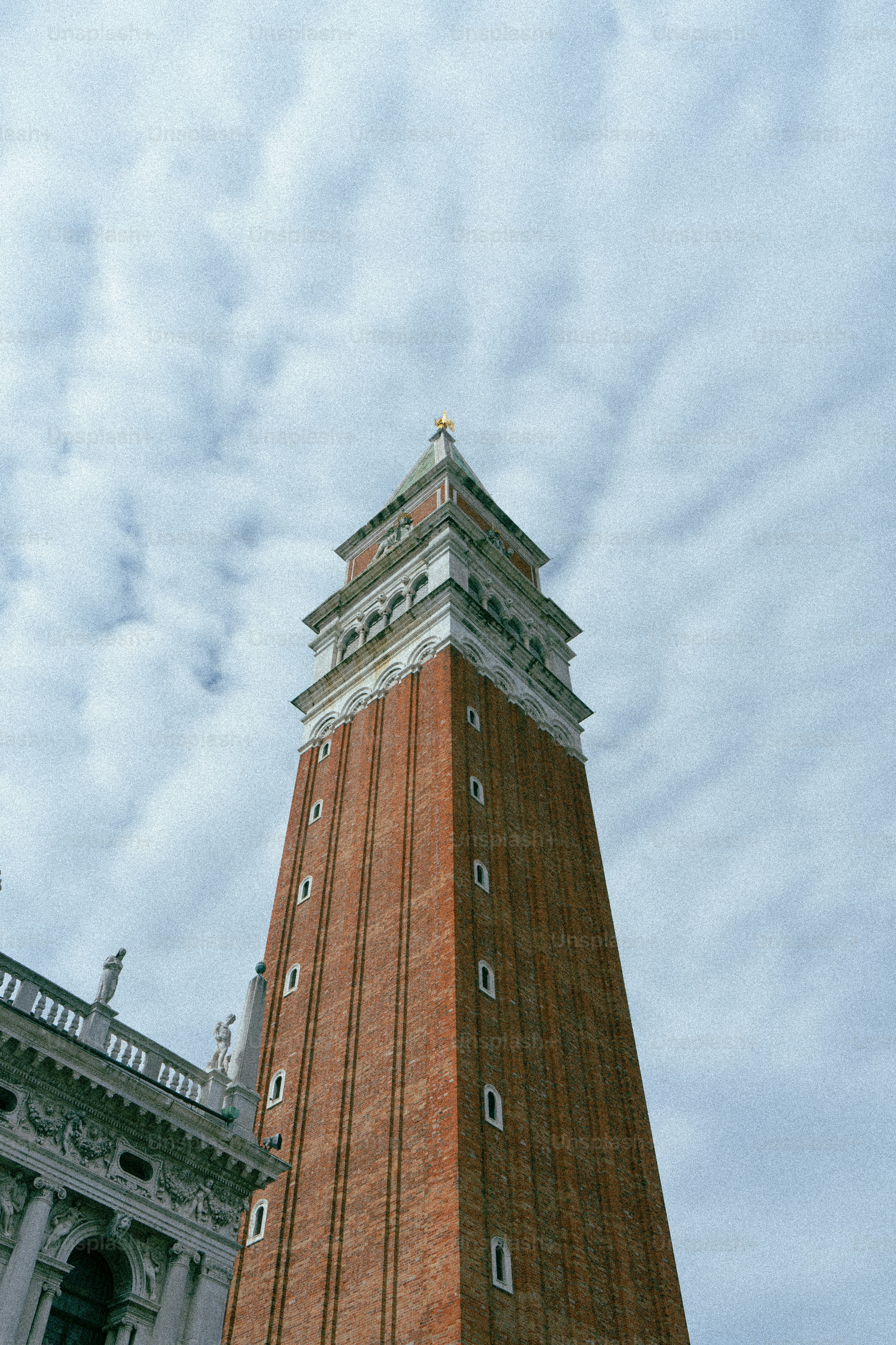 Hoher Backstein-Glockenturm vor einem wolkigen Himmel