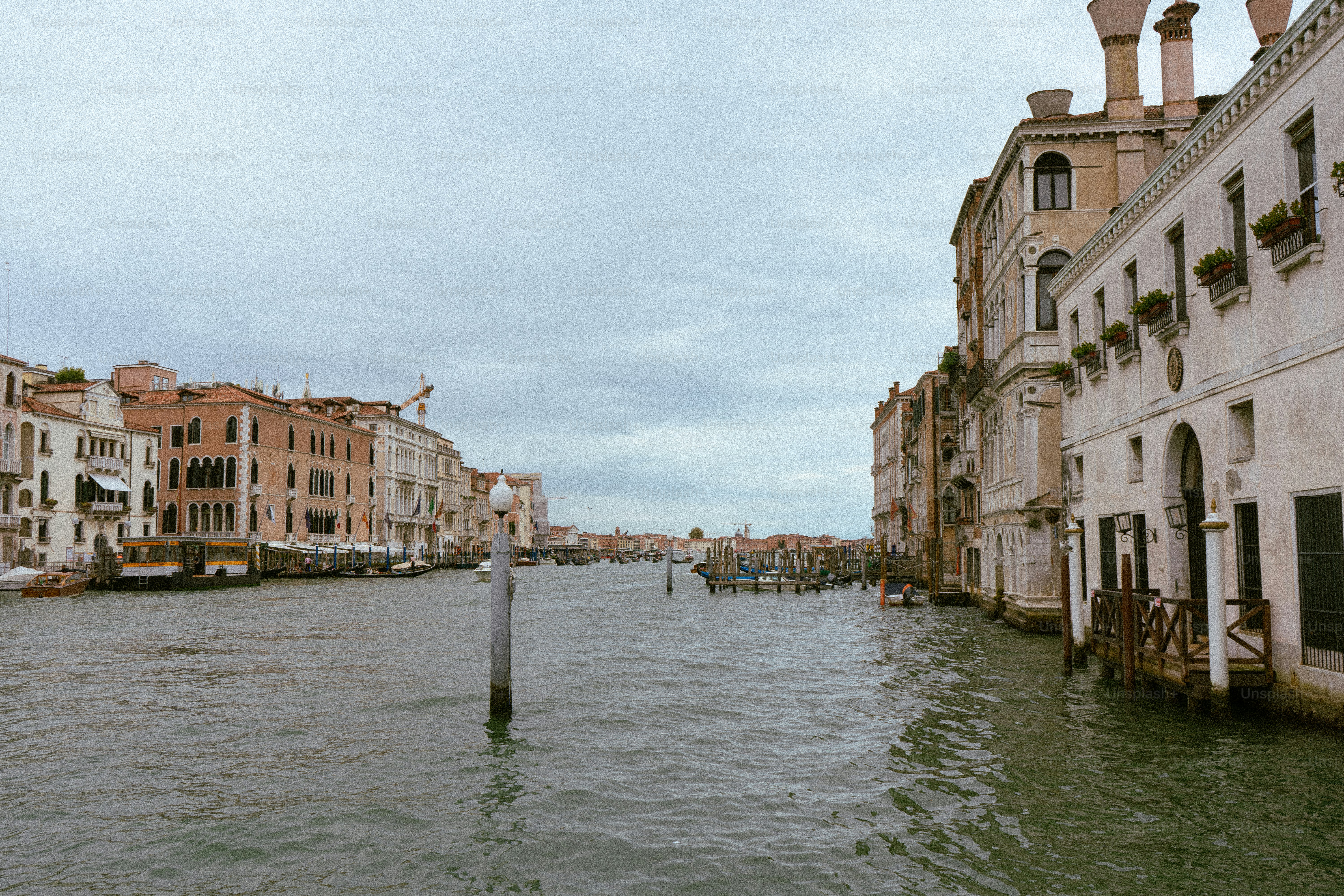 Gebäude säumen einen Kanal unter bewölktem Himmel.
