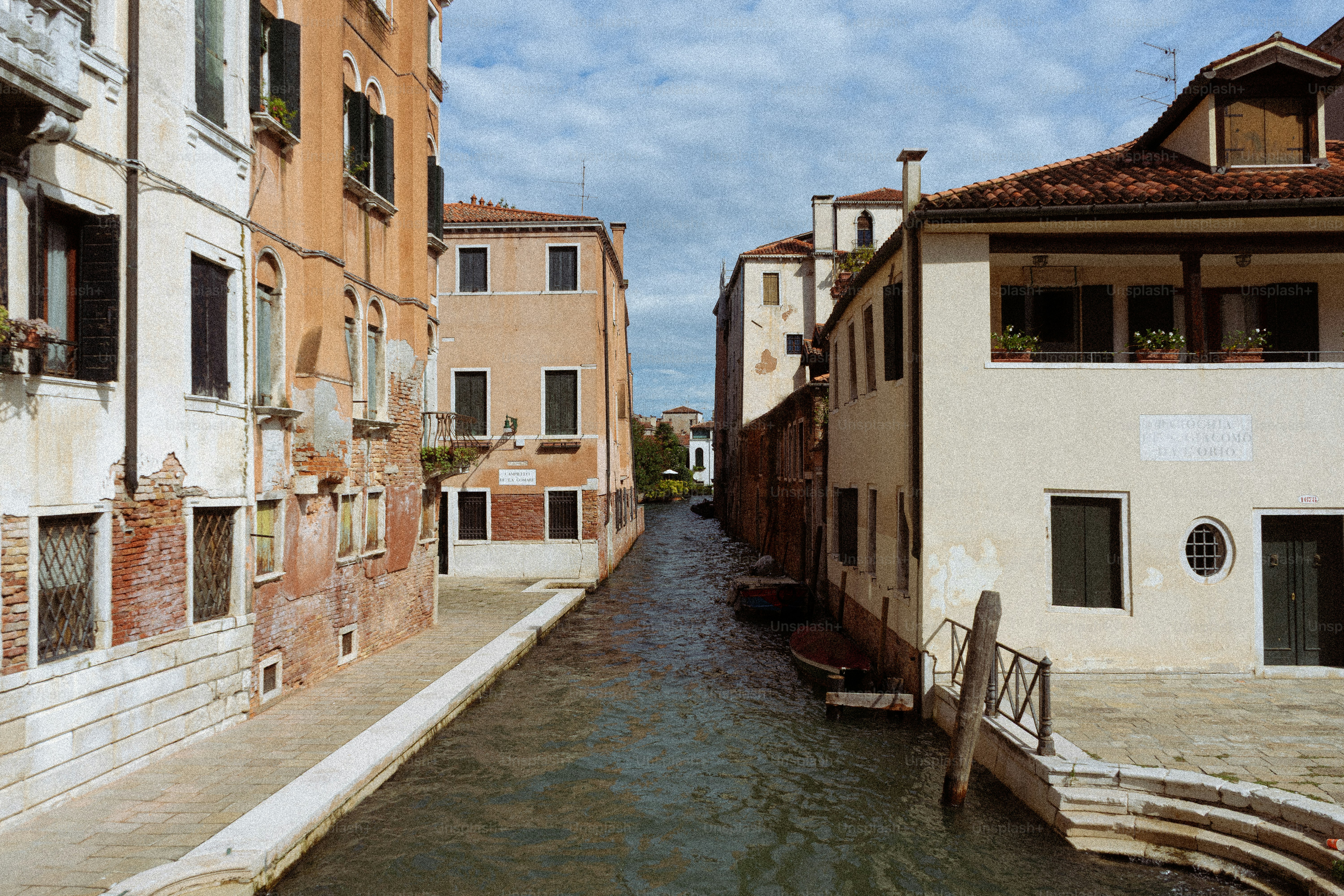 Venezianischer Kanal mit historischen Gebäuden und bewölktem Himmel