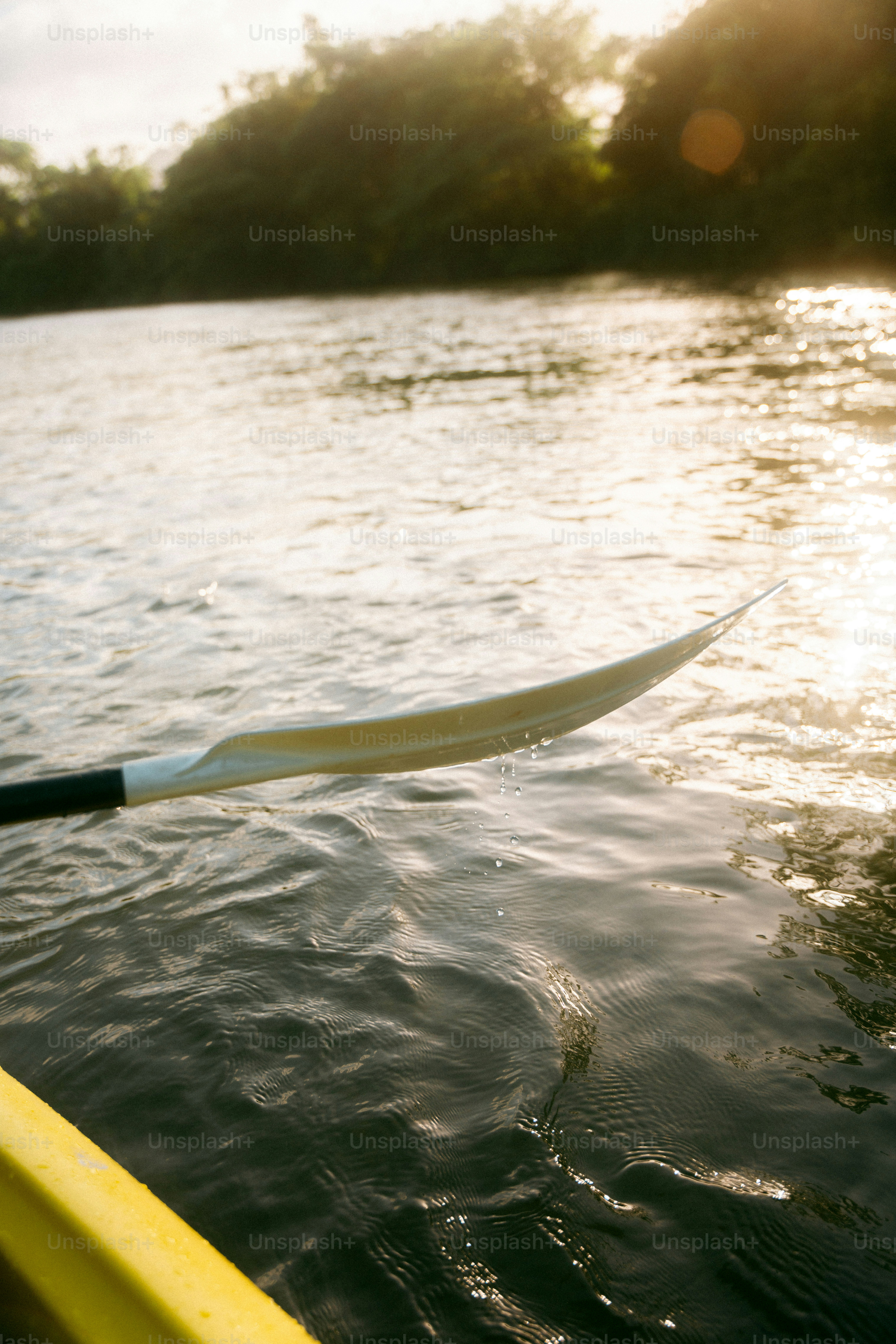 Kayaker paddling on a calm river at sunrise