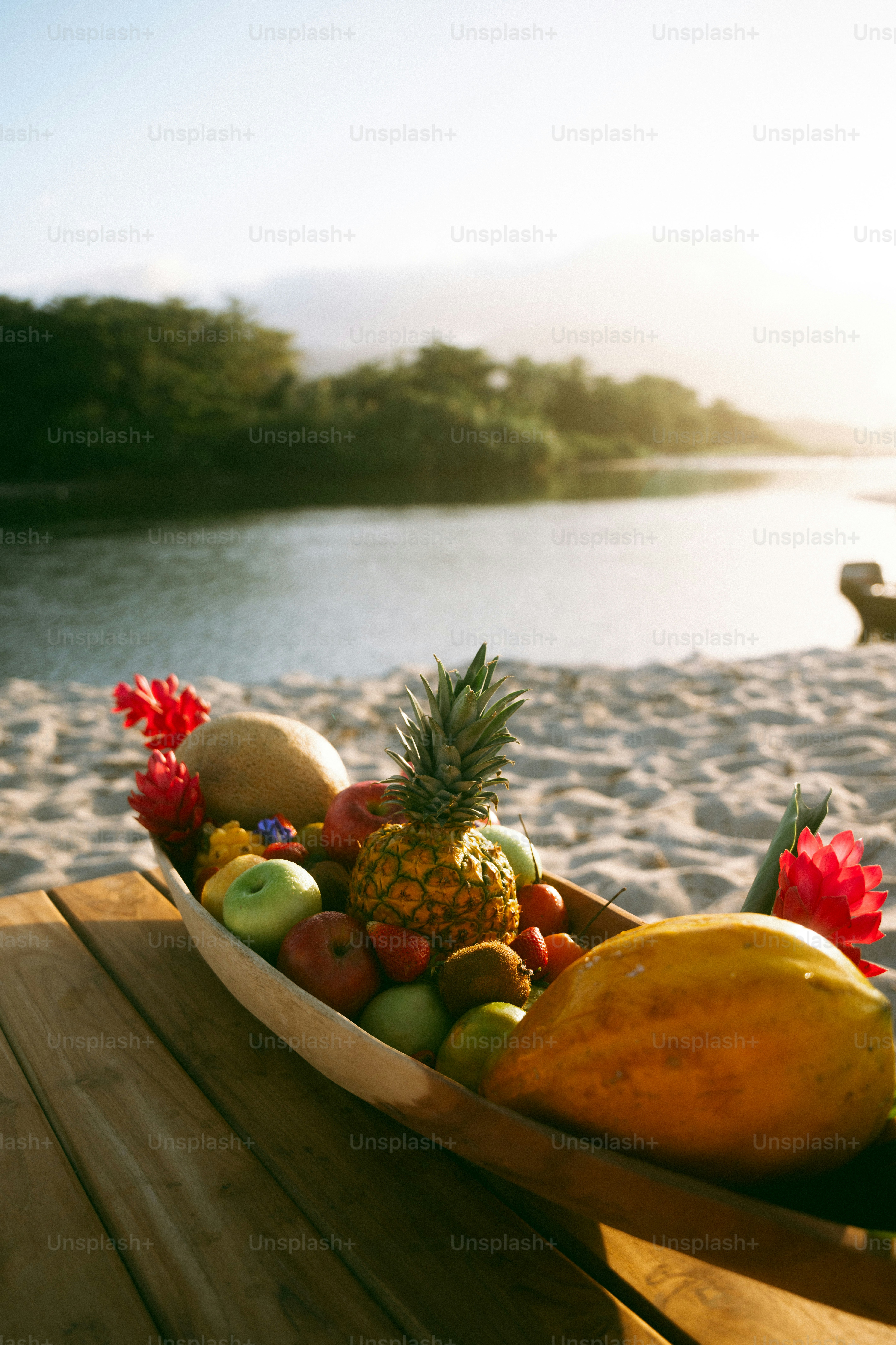 Bowl of tropical fruits on a beach near water