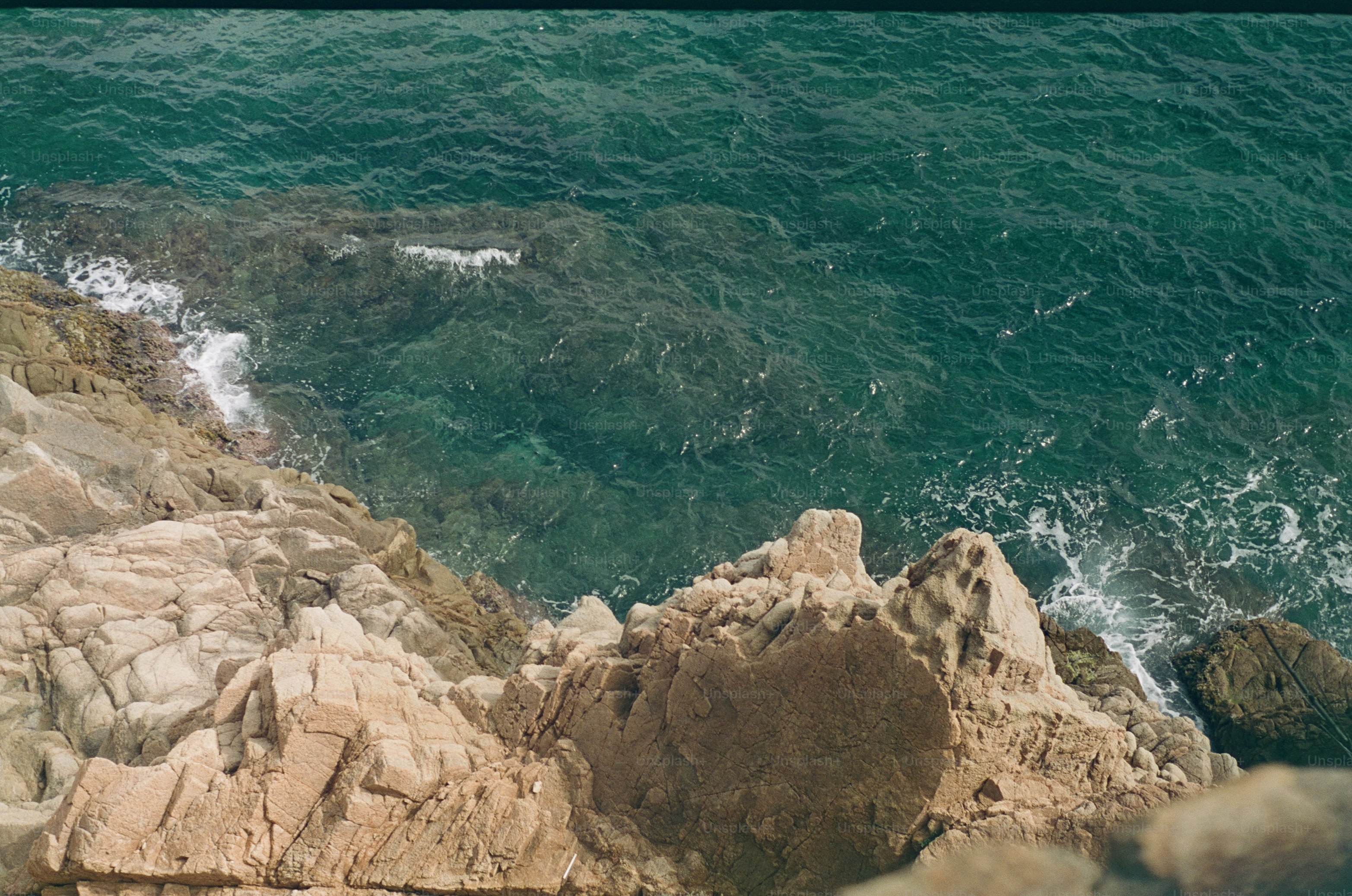 Waves crashing on rocky coastline from above