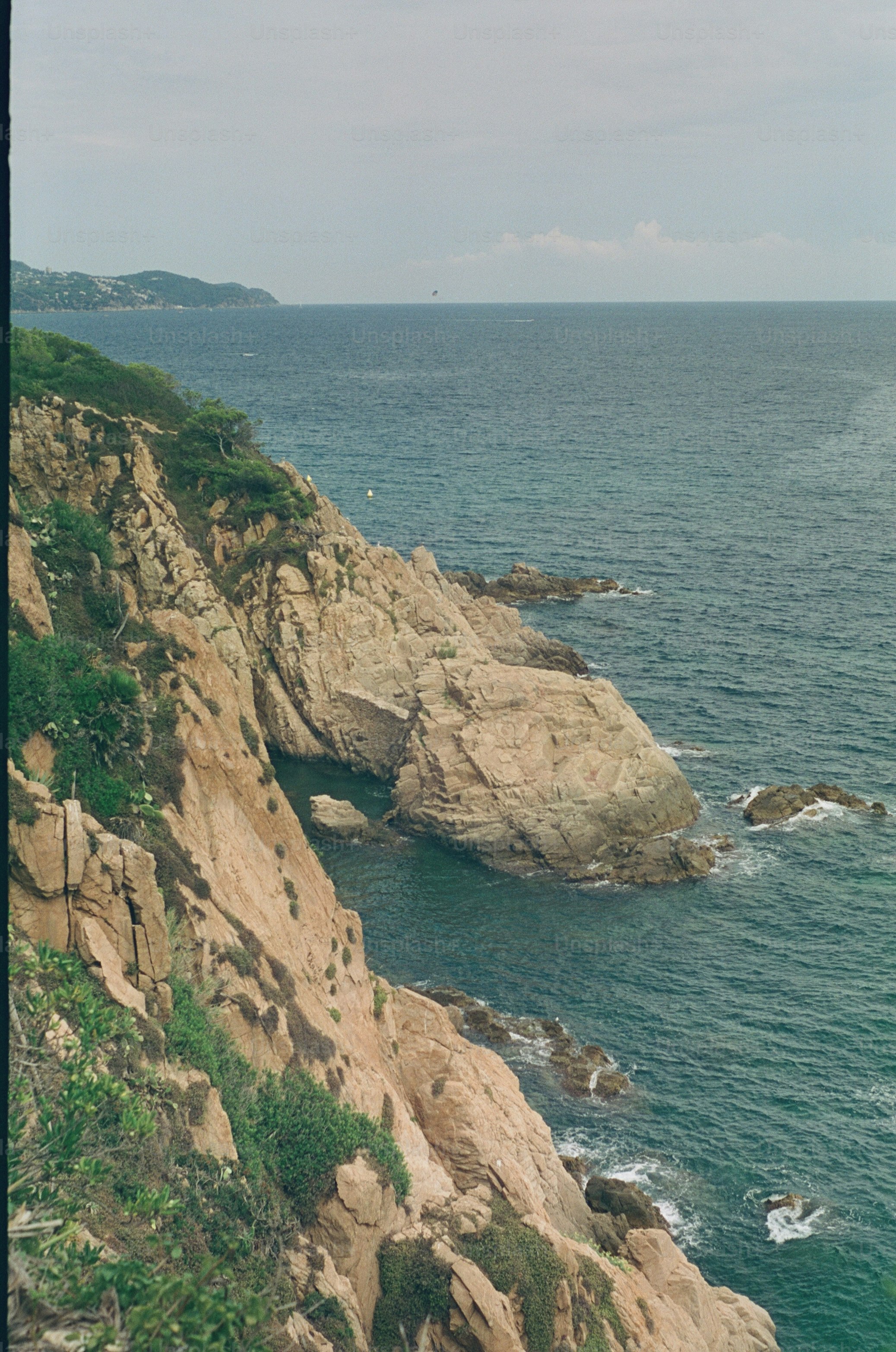 Rocky coastline with ocean waves crashing below.