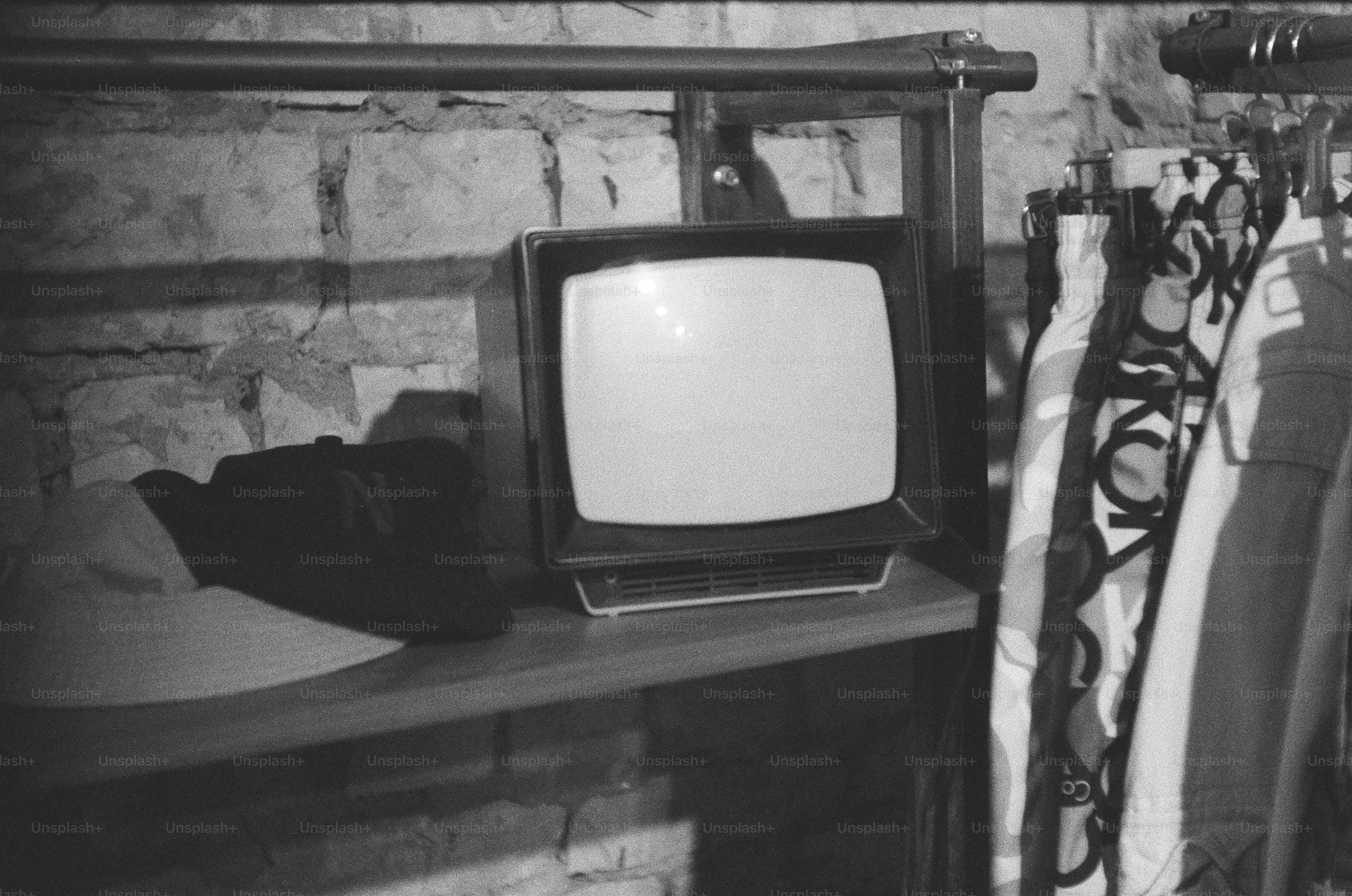 Vintage television set on a shelf with clothes.