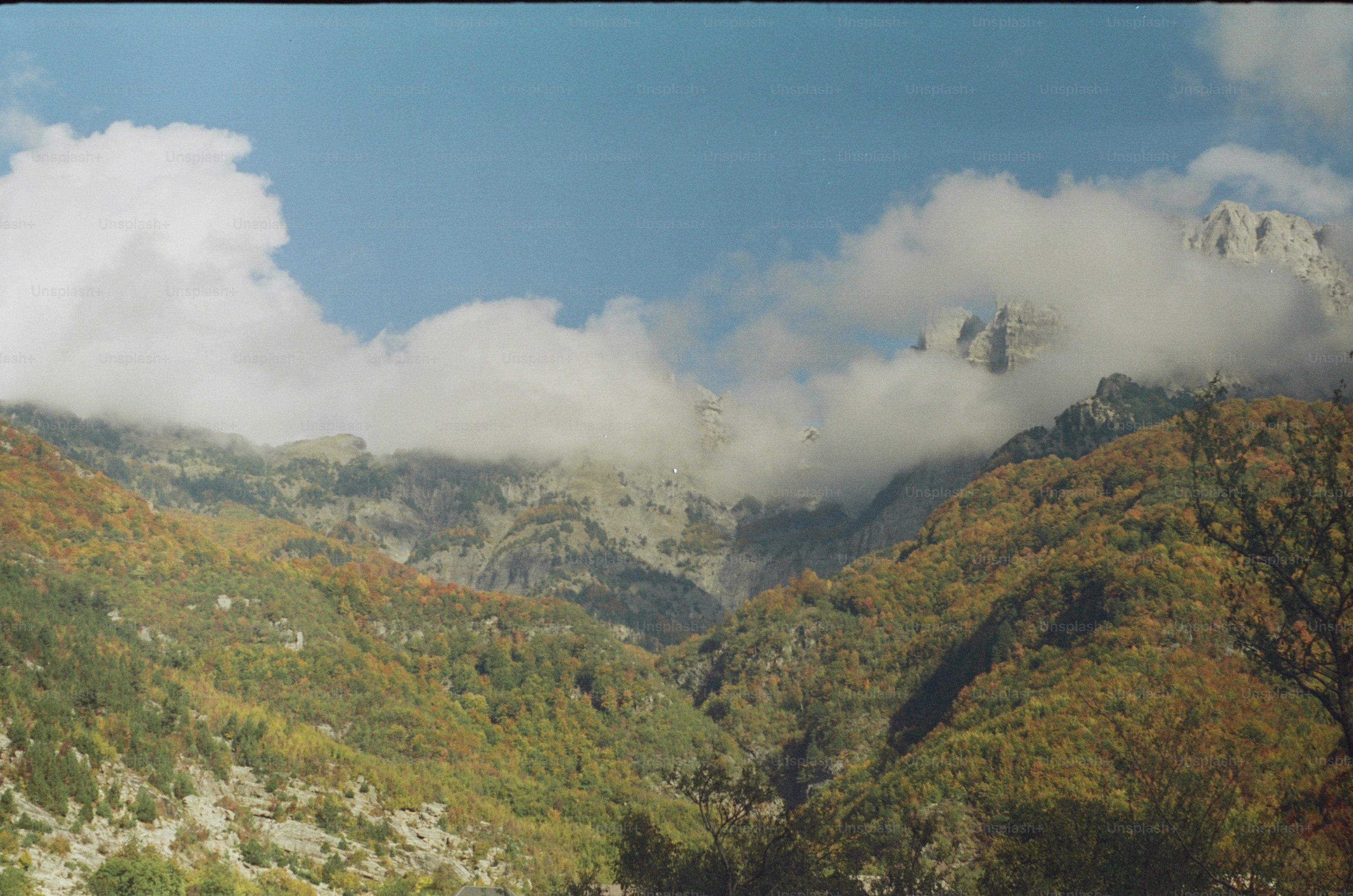 Autumn mountain landscape with clouds and trees