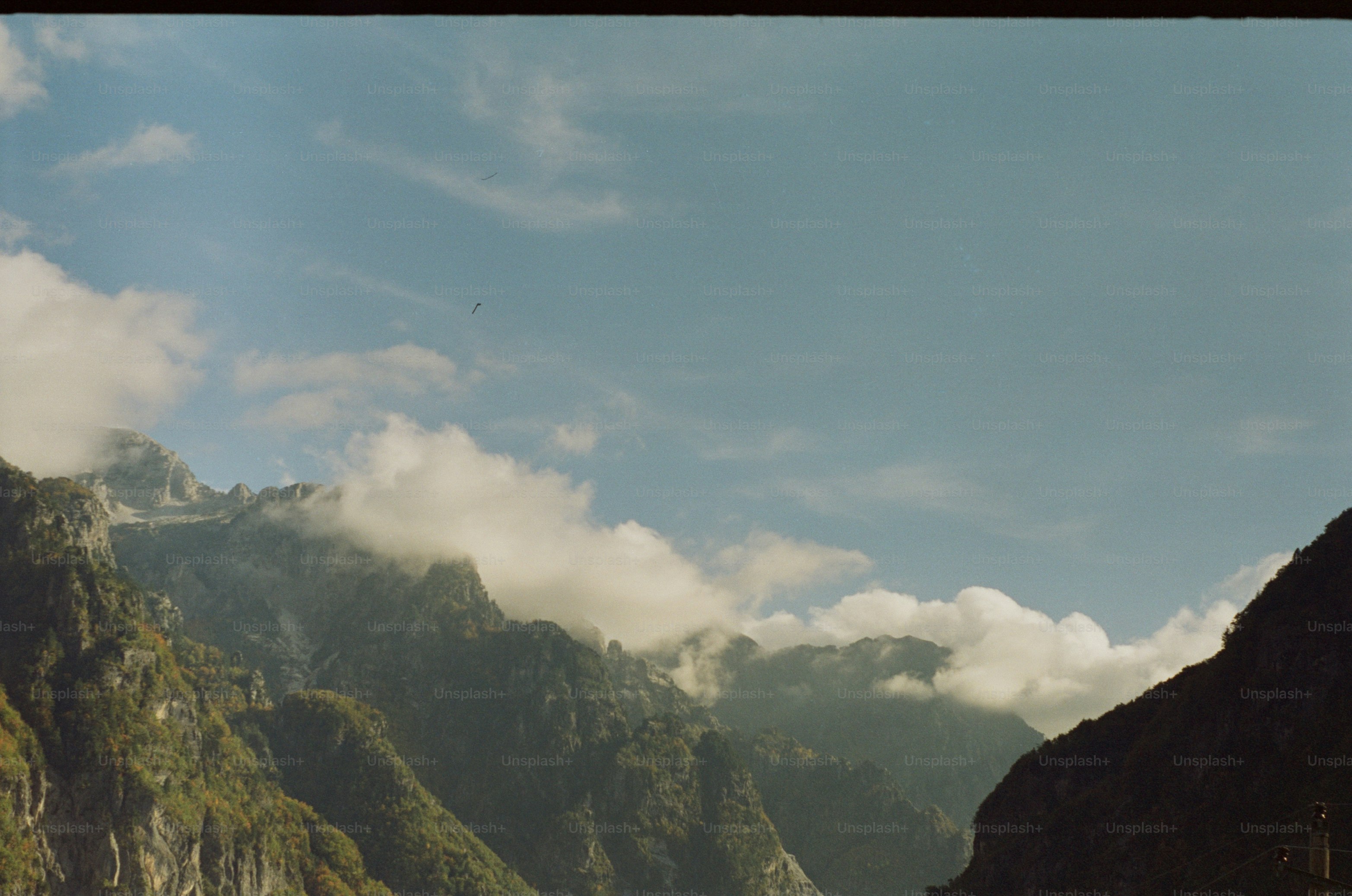 Misty mountains under a cloudy blue sky