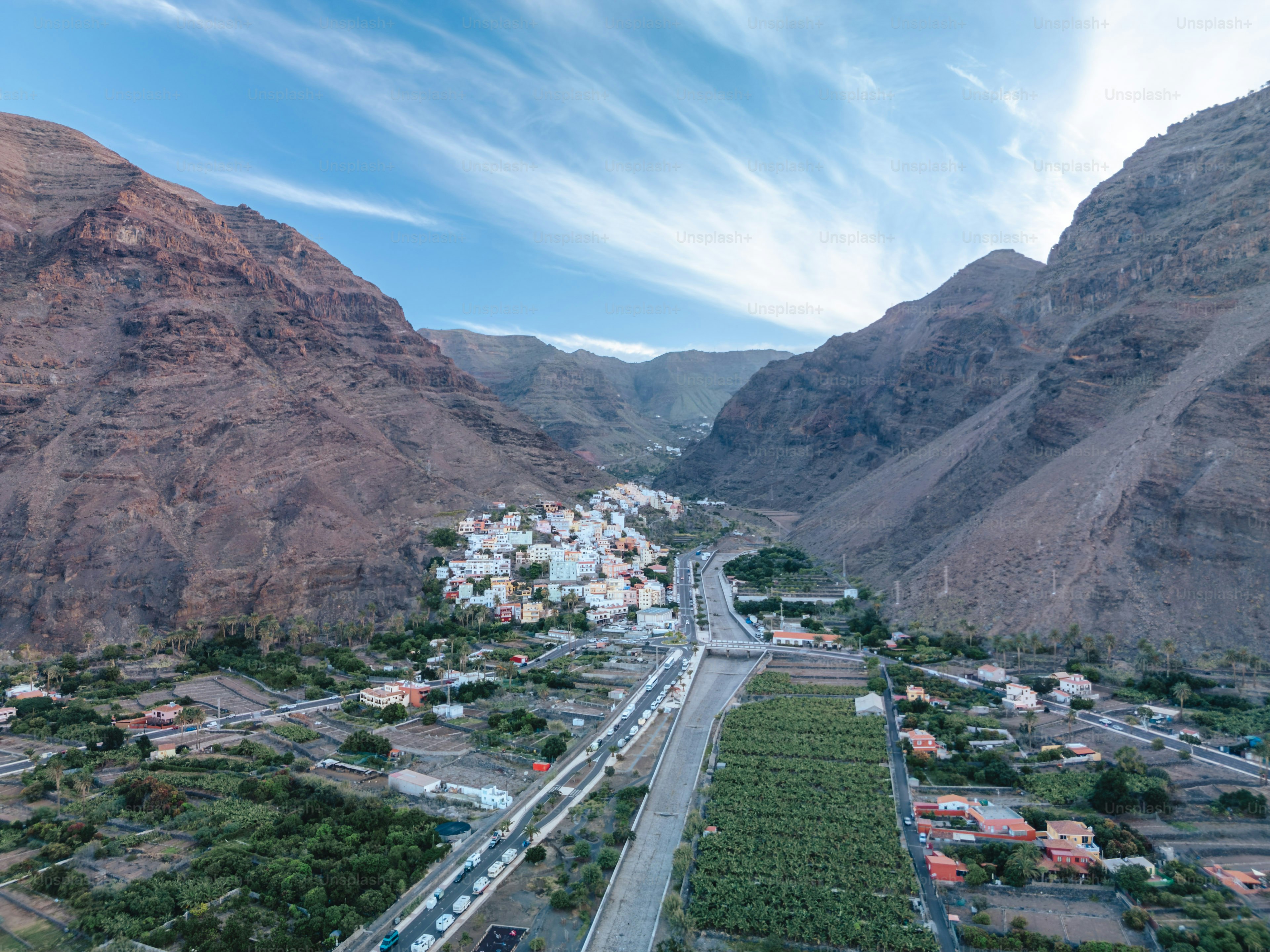 A small village nestled between steep, rocky mountains. photo ...