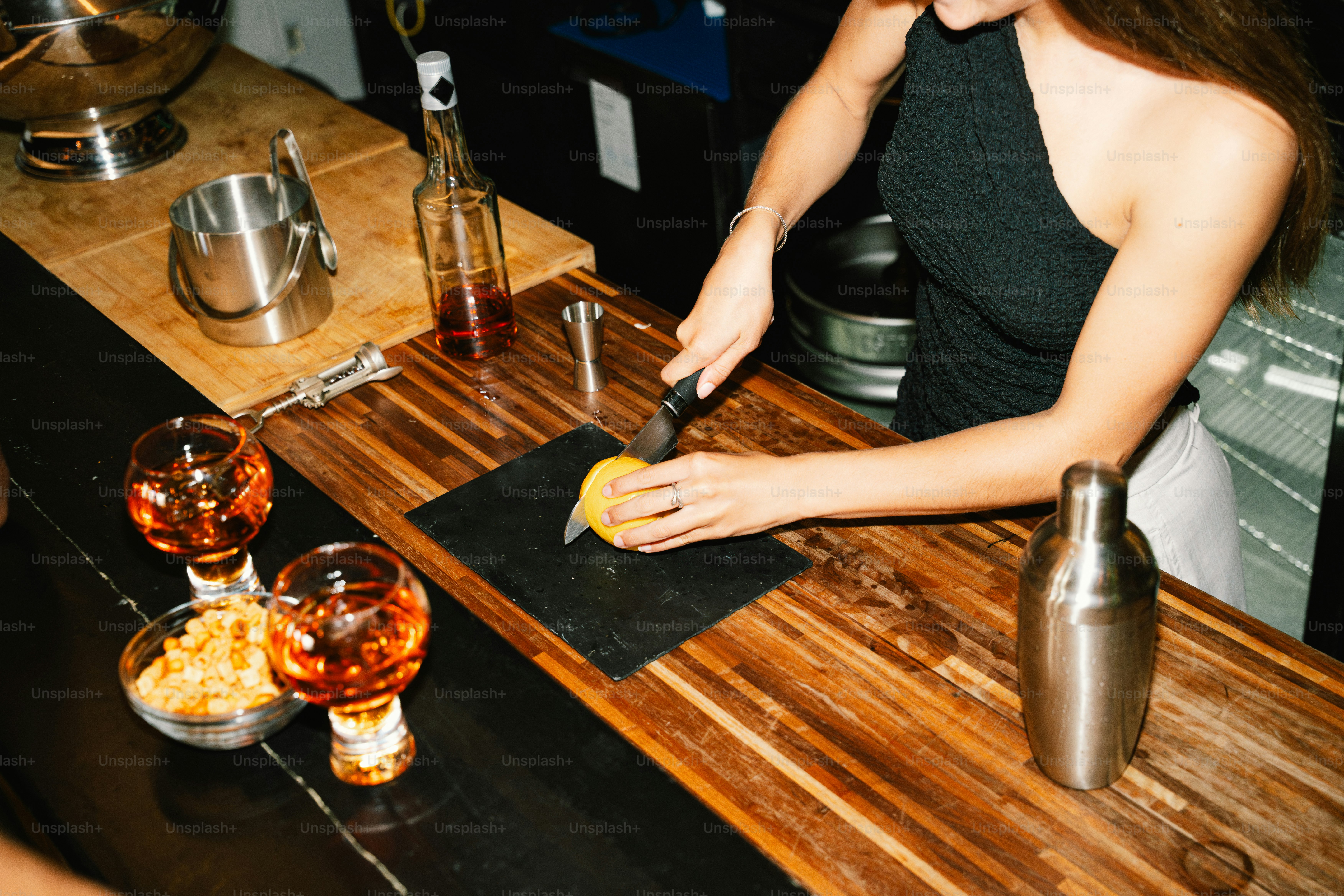 Bartender slicing fruit behind a bar