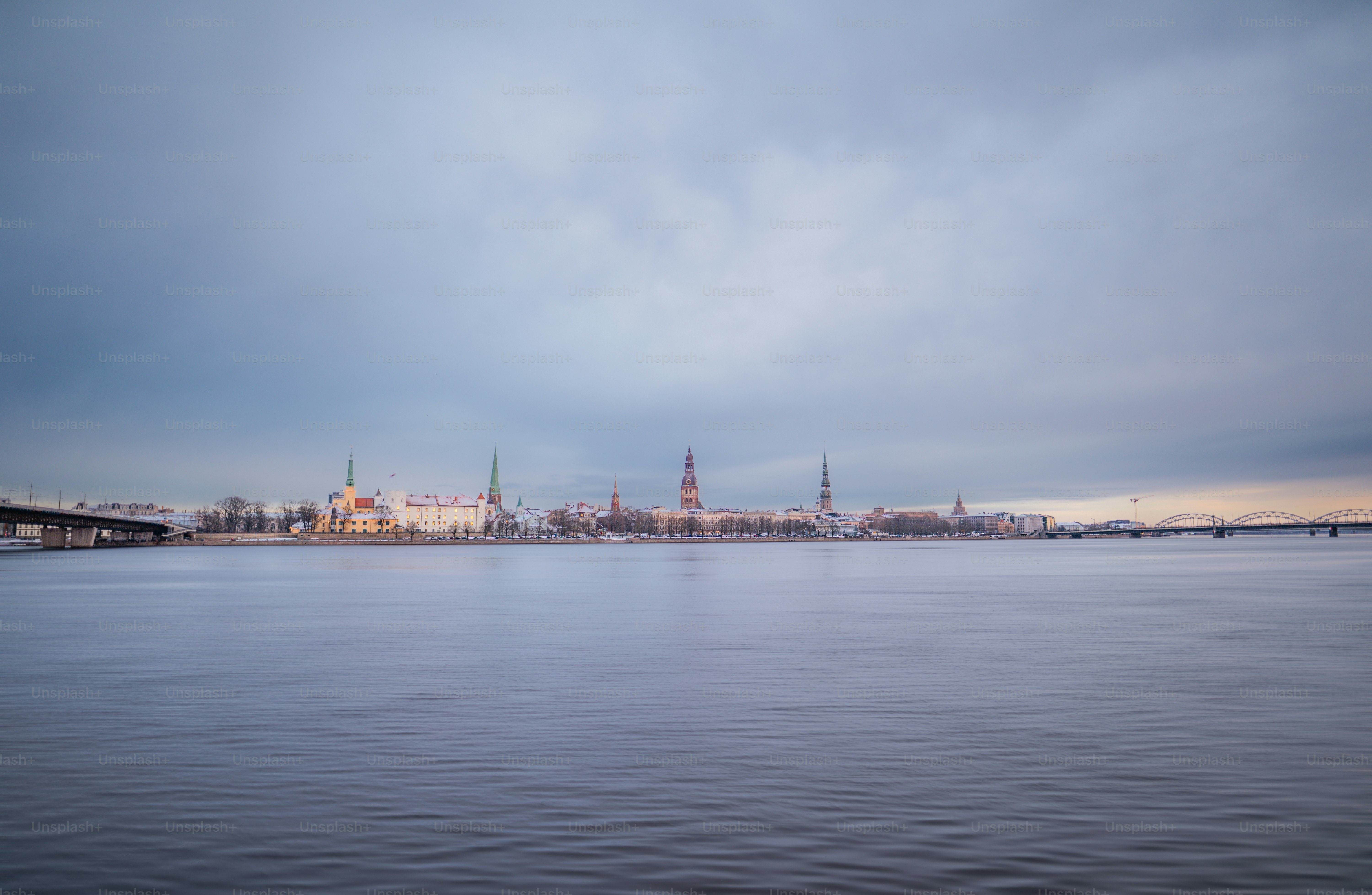Stadtsilhouette über einen zugefrorenen Fluss unter wolkigem Himmel