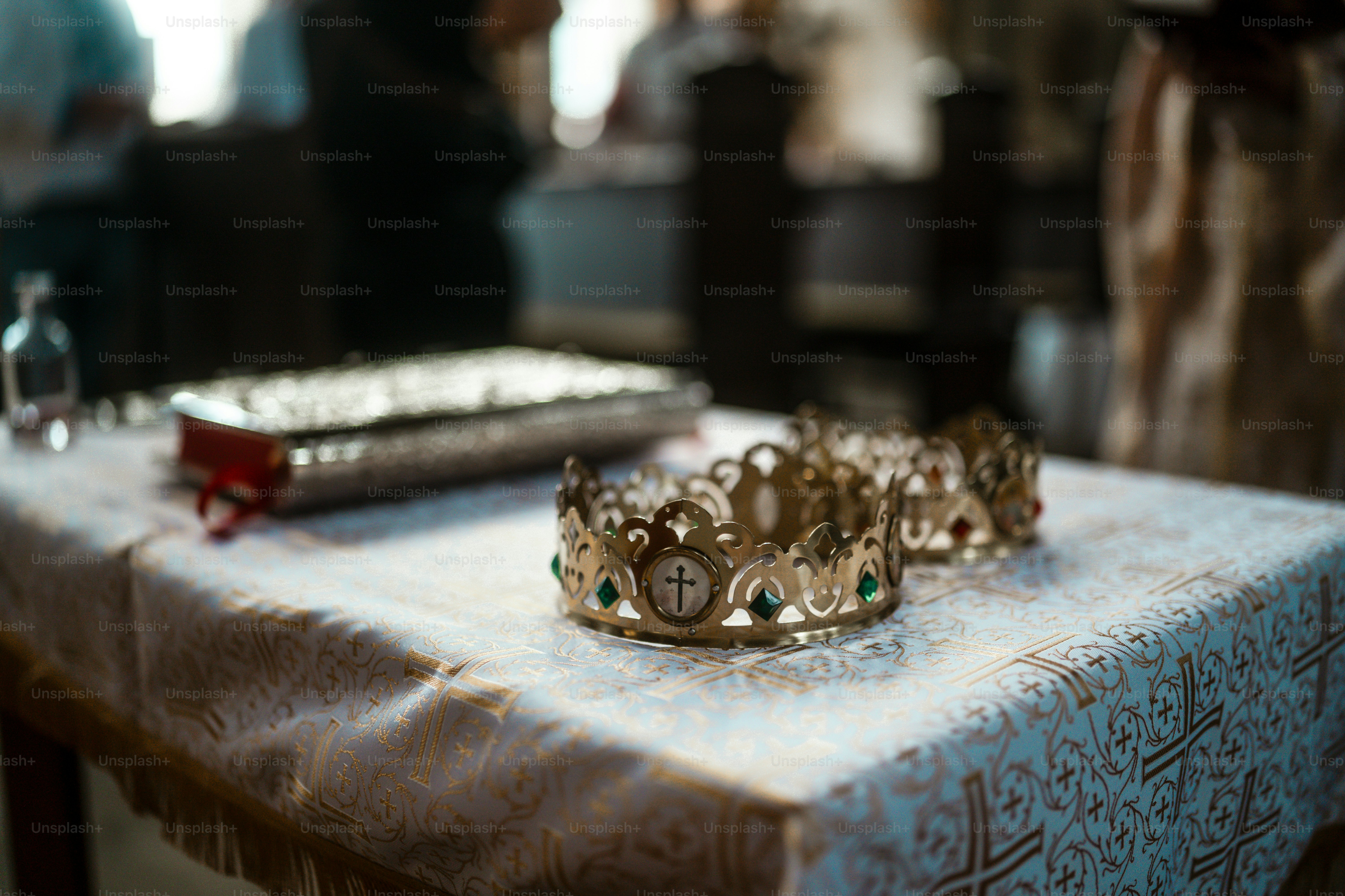 Two ornate crowns on a decorated table