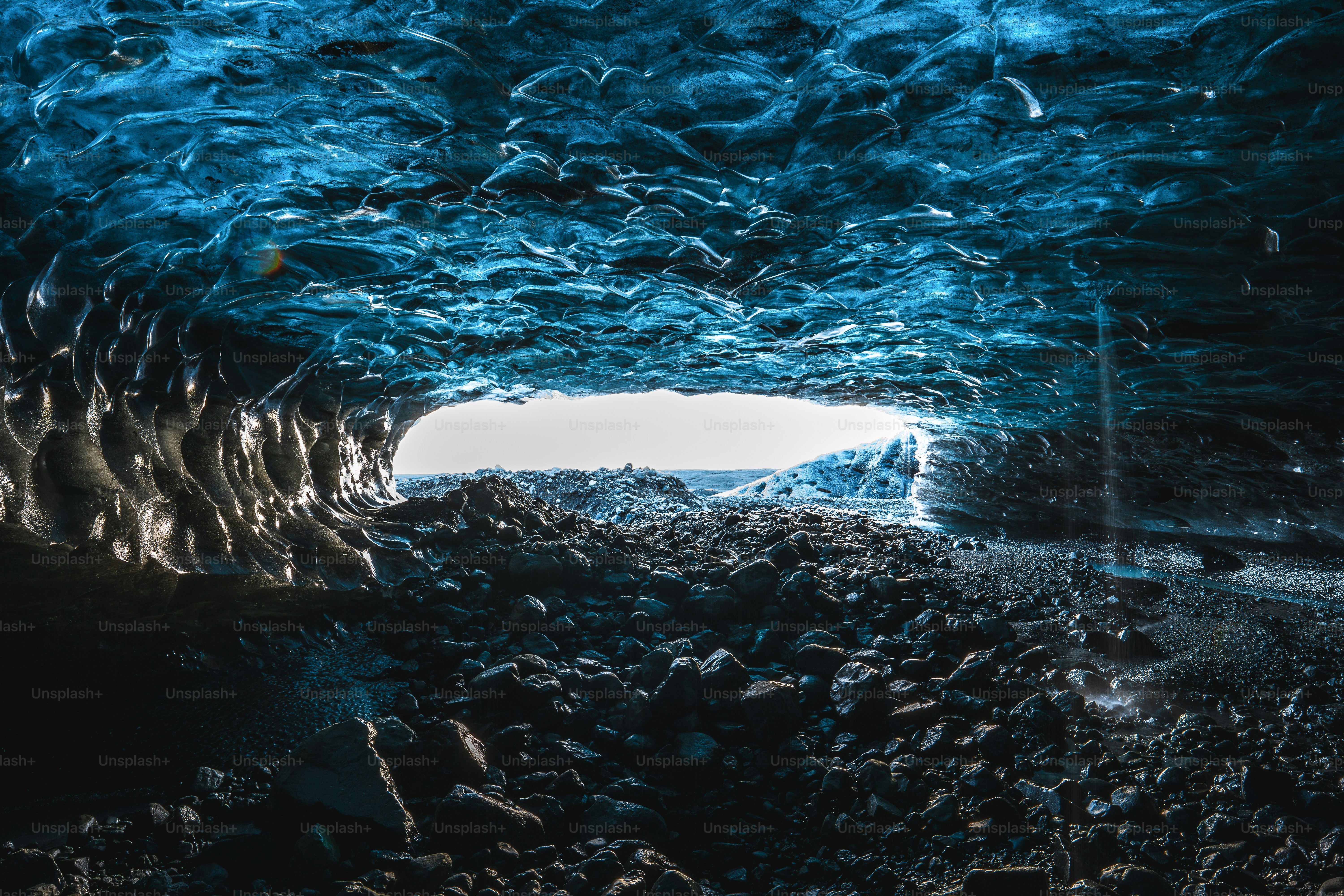 Inside a glowing blue ice cave with rocky floor photo – Cold Image on ...