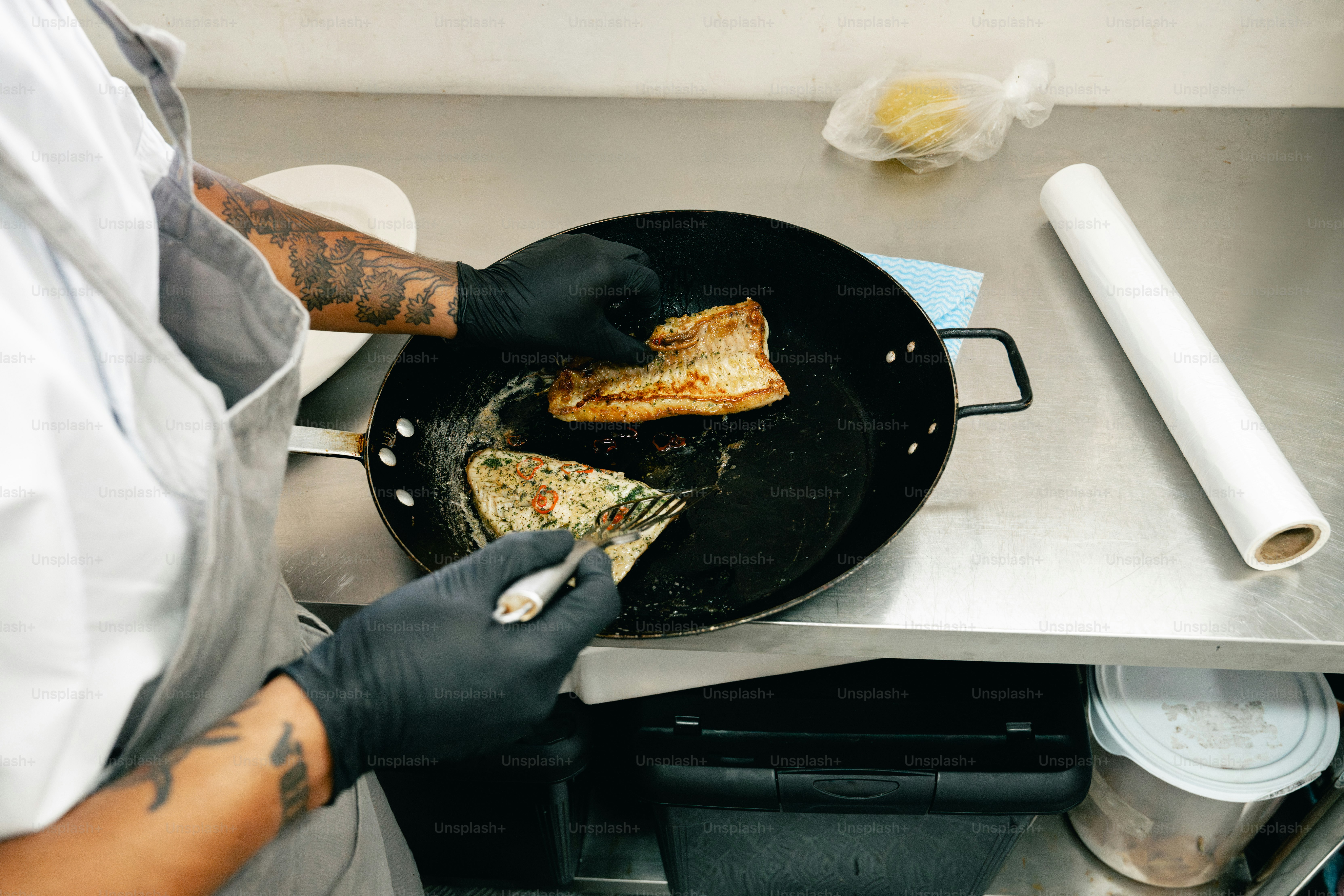 Chef cocinando pescado en una sartén